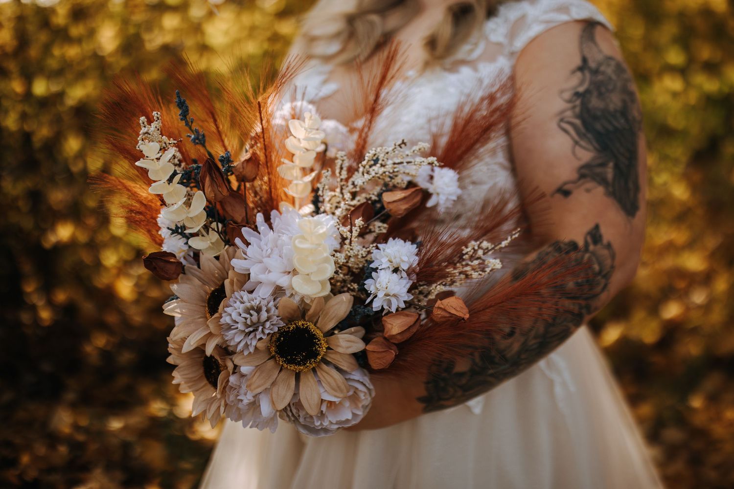 A detailed shot of a rustic autumn wedding bouquet with white flowers and fall foliage.
