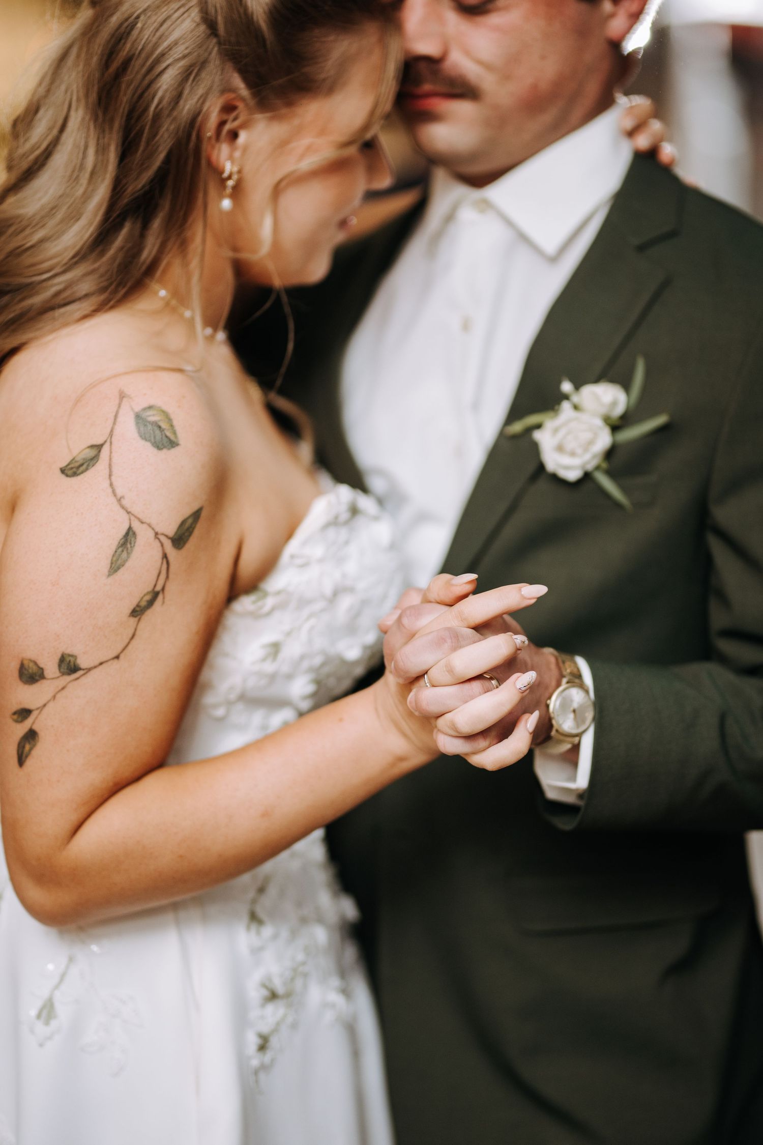 Close-up of a couple dancing together, with focus on their embracing hands.