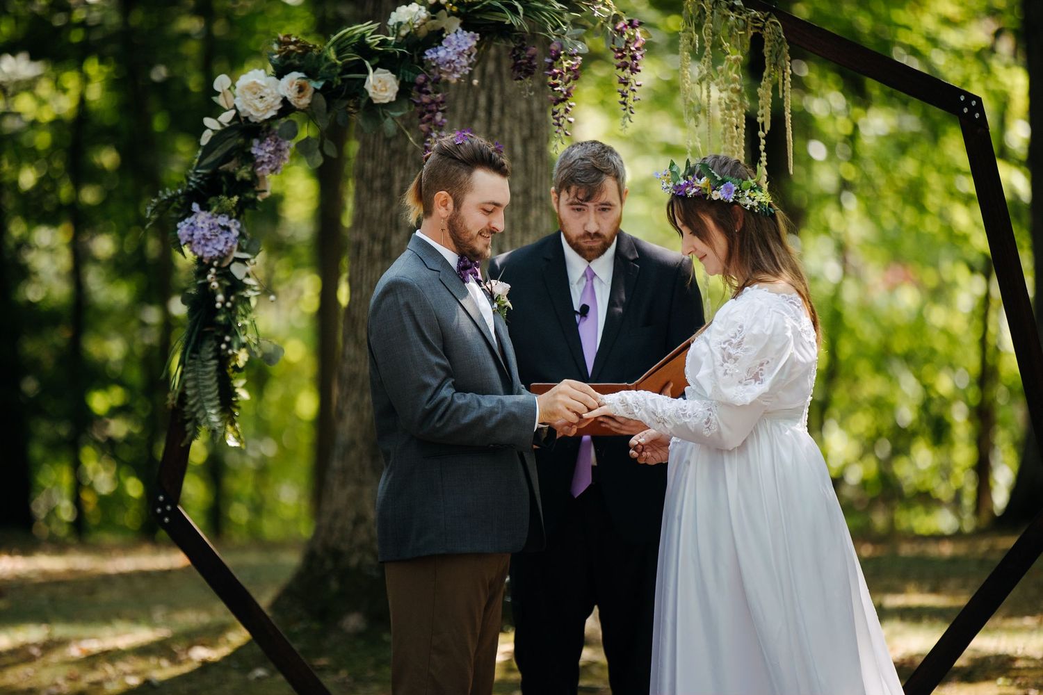 An outdoor wedding ceremony taking place in a lush green garden setting.