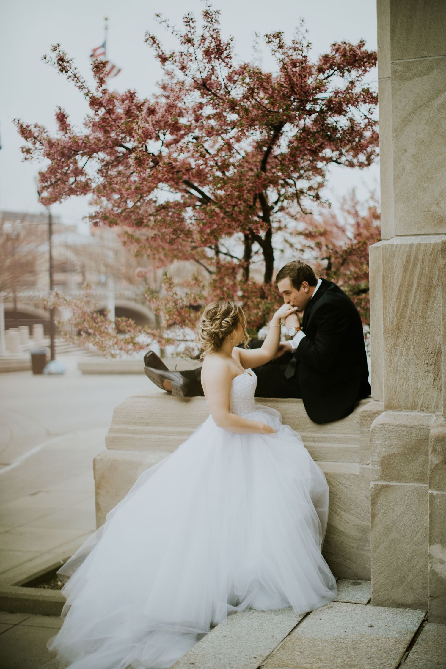Autumn wedding portrait with fall foliage and stone columns in the background.