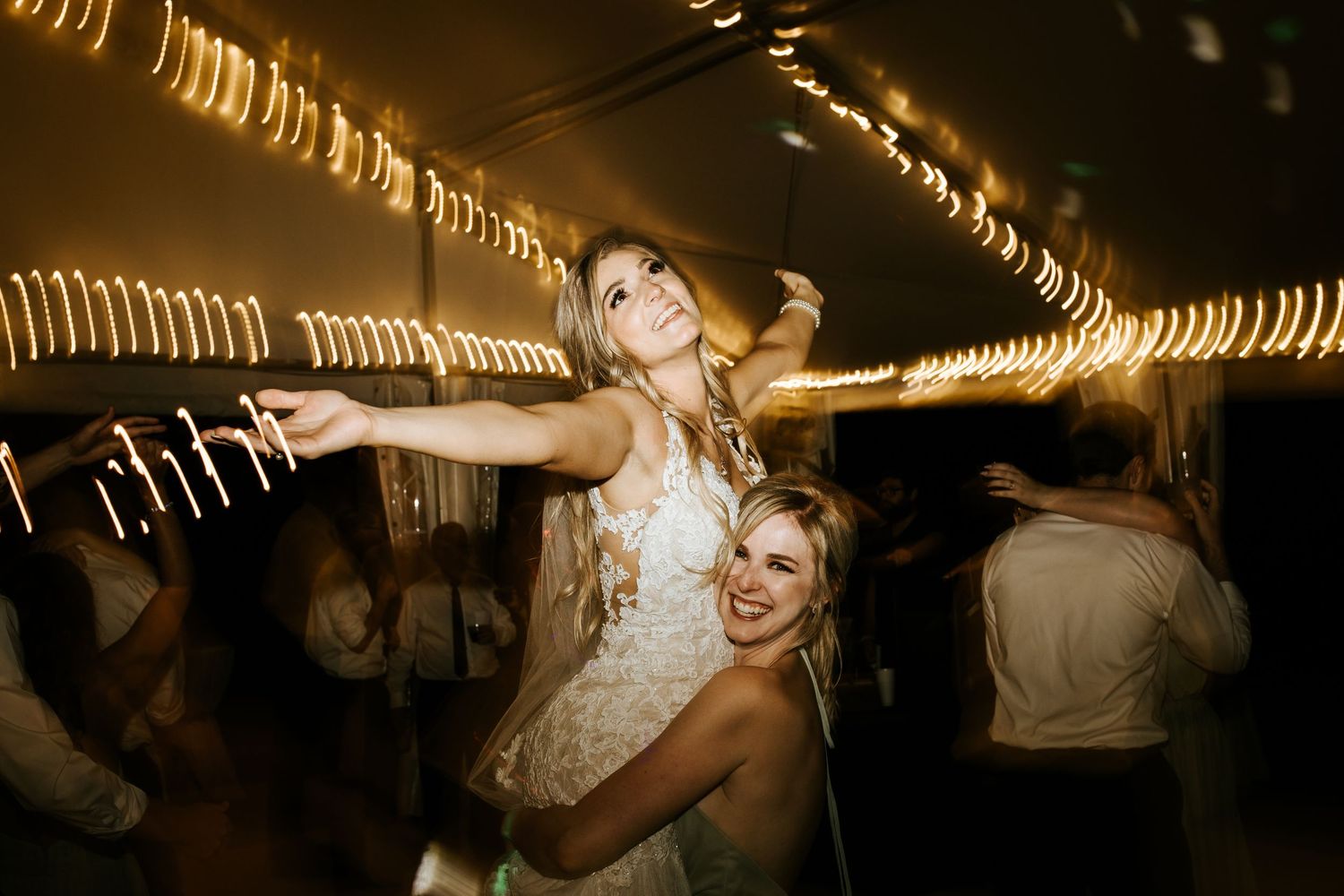 Wedding celebration in dark venue with artistic light trails and motion blur effects.