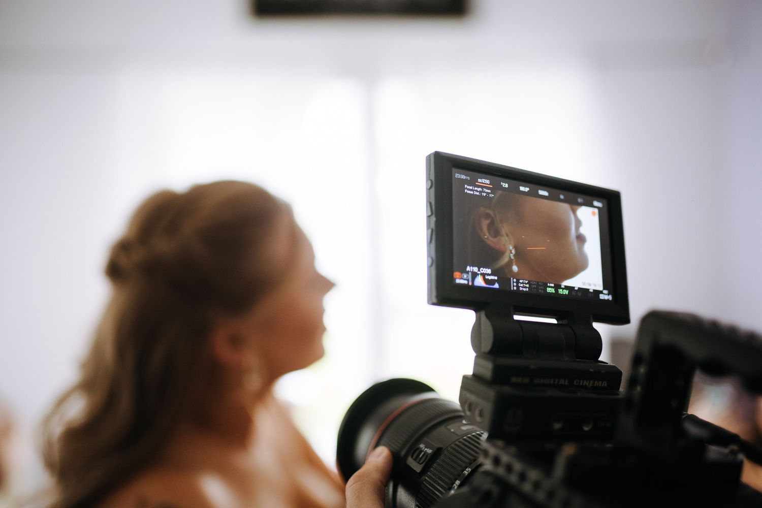 Professional videographer films wedding ceremony with camera equipment.