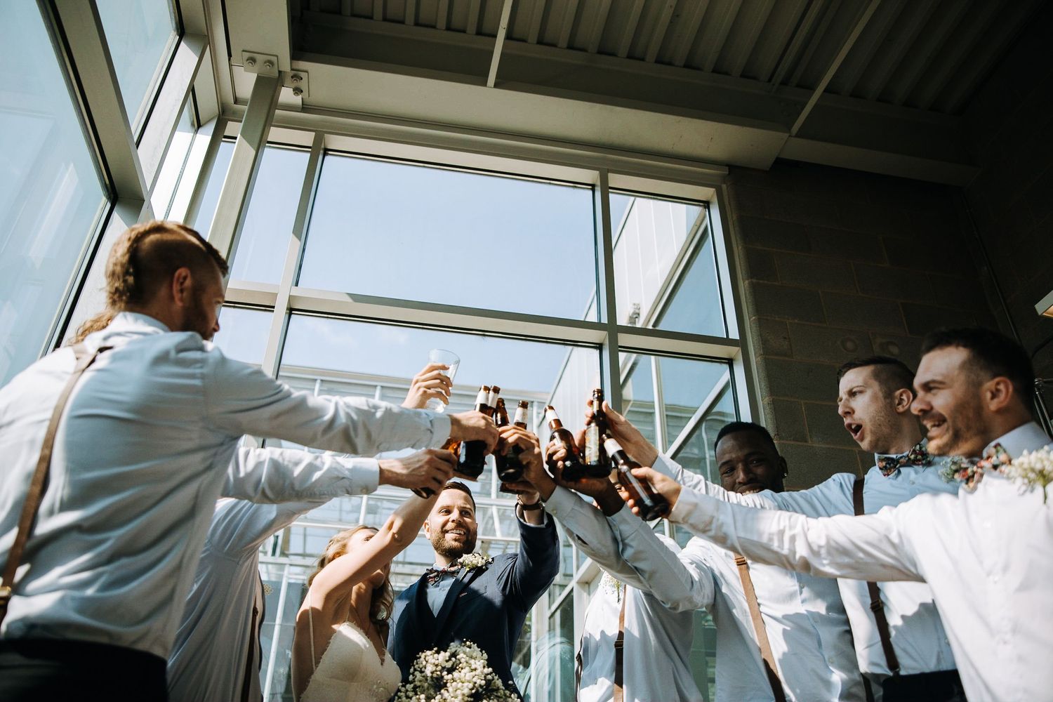 Wedding party raises glasses in celebratory toast during reception.