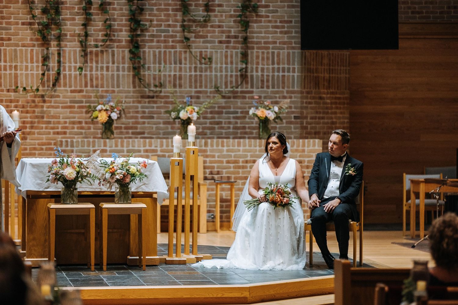 Wedding ceremony in a modern church with brick walls and wooden details.