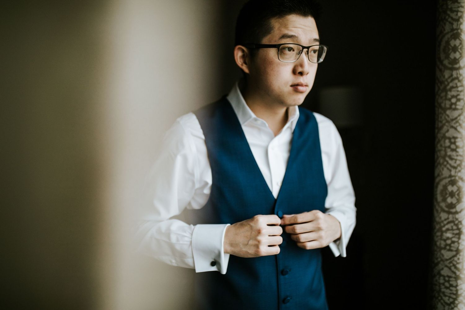 Professional portrait series showing a person in glasses and navy vest against textured wall in natural light.