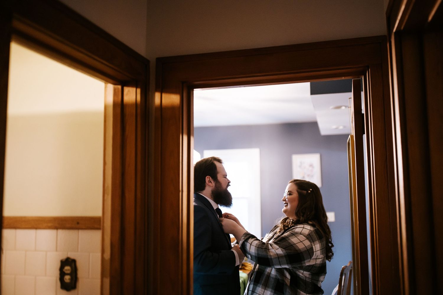 Two people share a conversation in a warmly lit doorway.