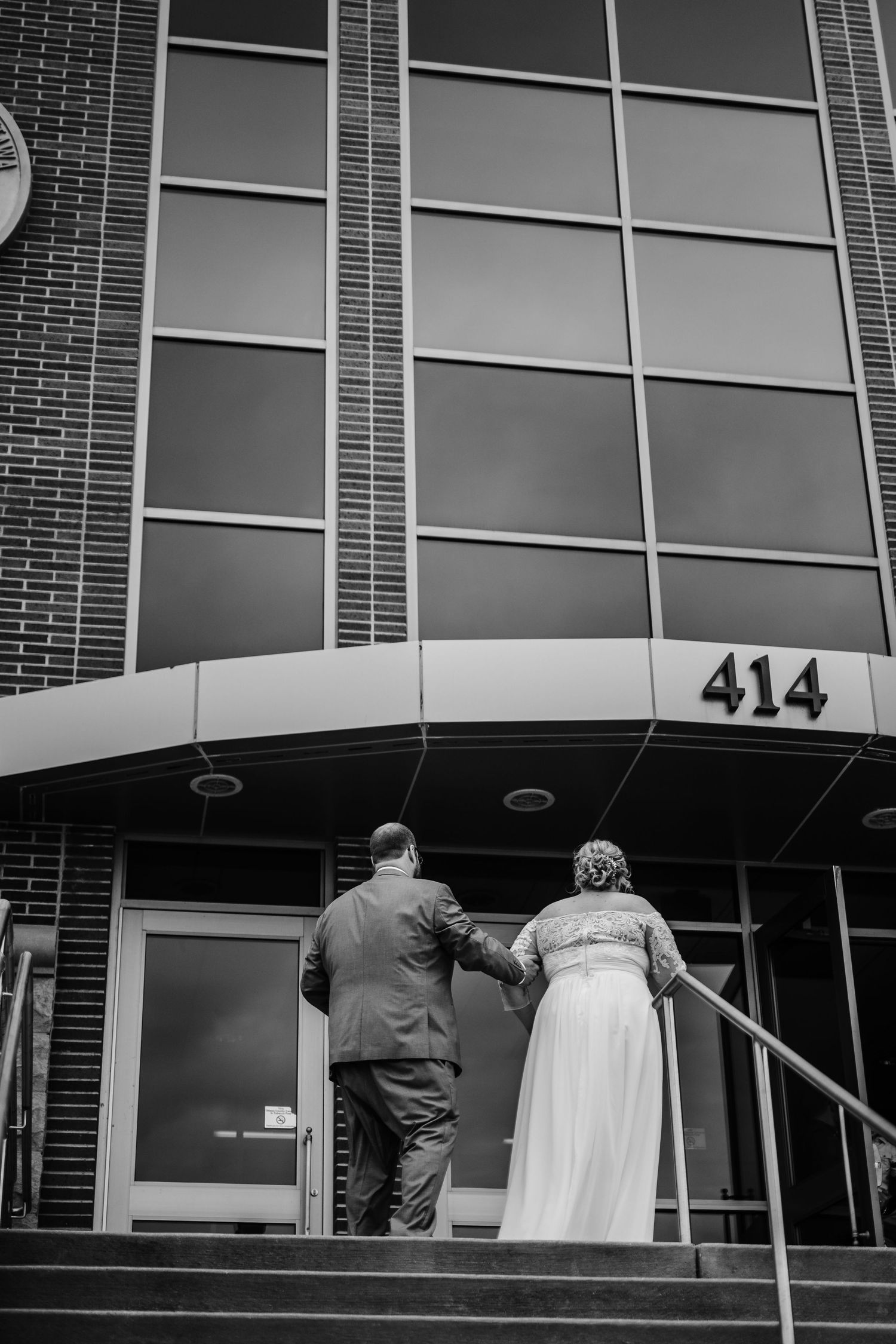 A couple enters building 414 together on their wedding day.