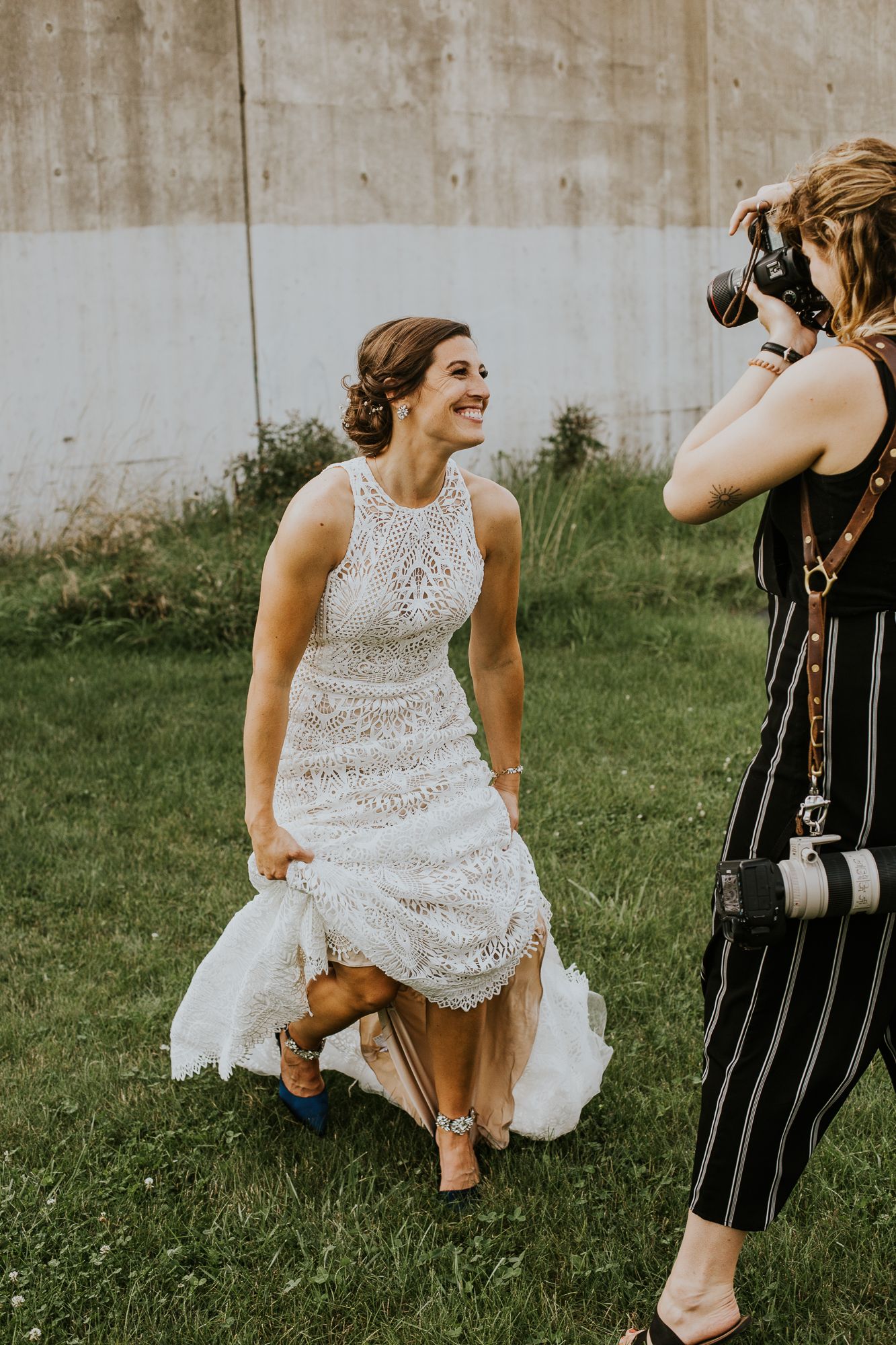 Person in white lace dress showing off blue shoes while others in striped outfits look on.