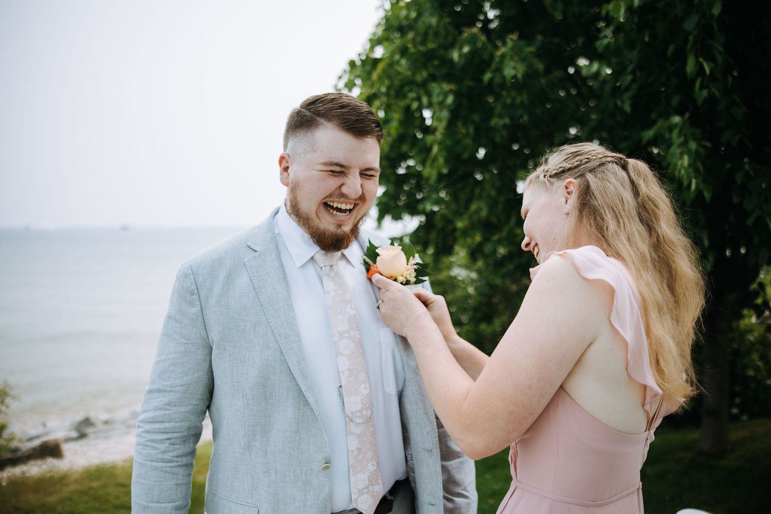 A couple shares a romantic moment during their outdoor wedding photoshoot by the water.