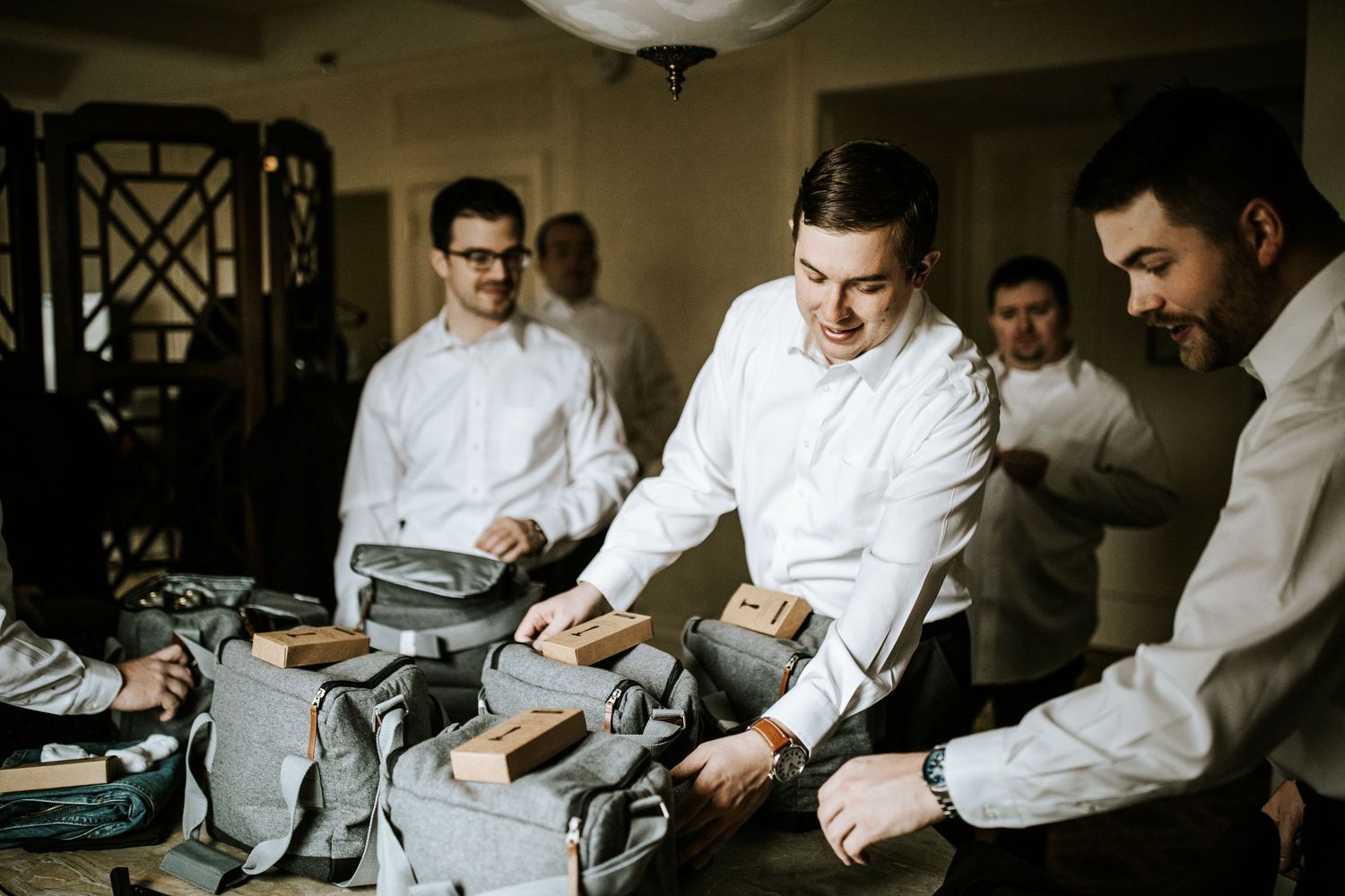 Groomsmen getting ready by adjusting their formal attire.
