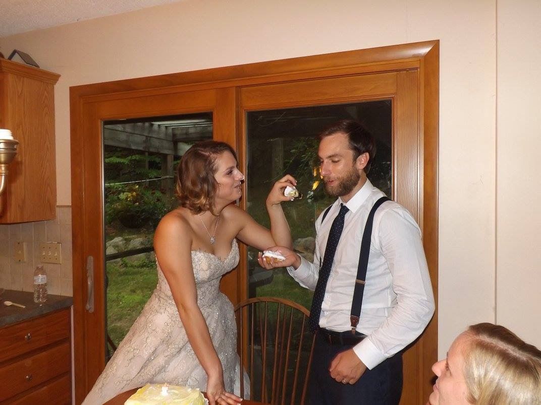 Couple sharing intimate moment in kitchen during celebration.