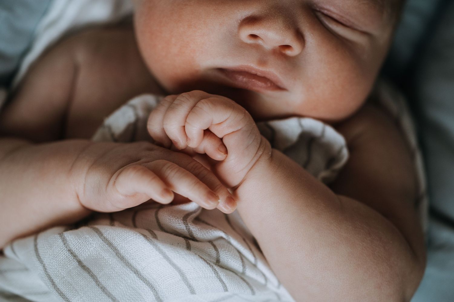Intimate close-up detail shot of gentle hands and soft lighting.