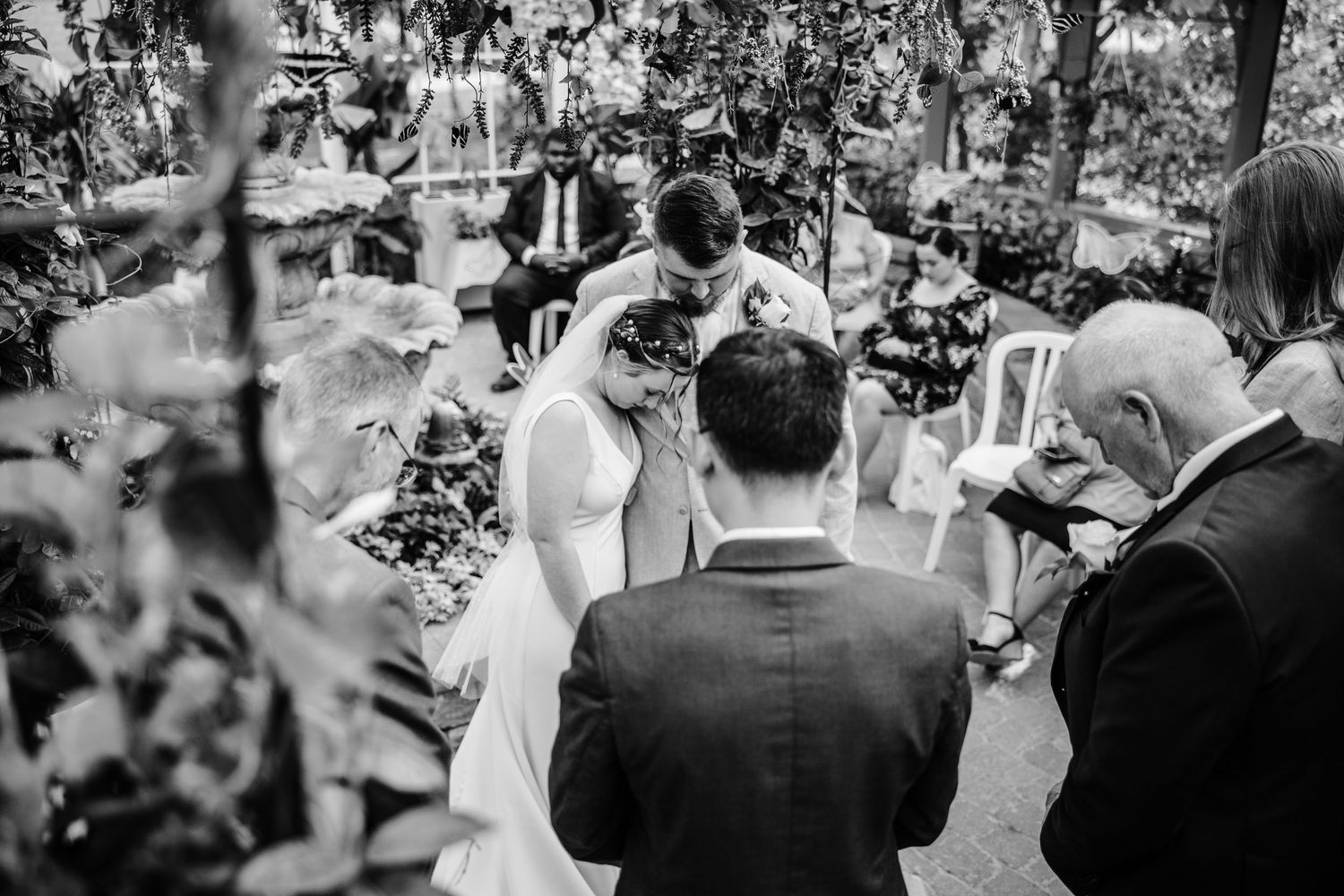 Black and white photo of wedding guests gathered for an outdoor ceremony.