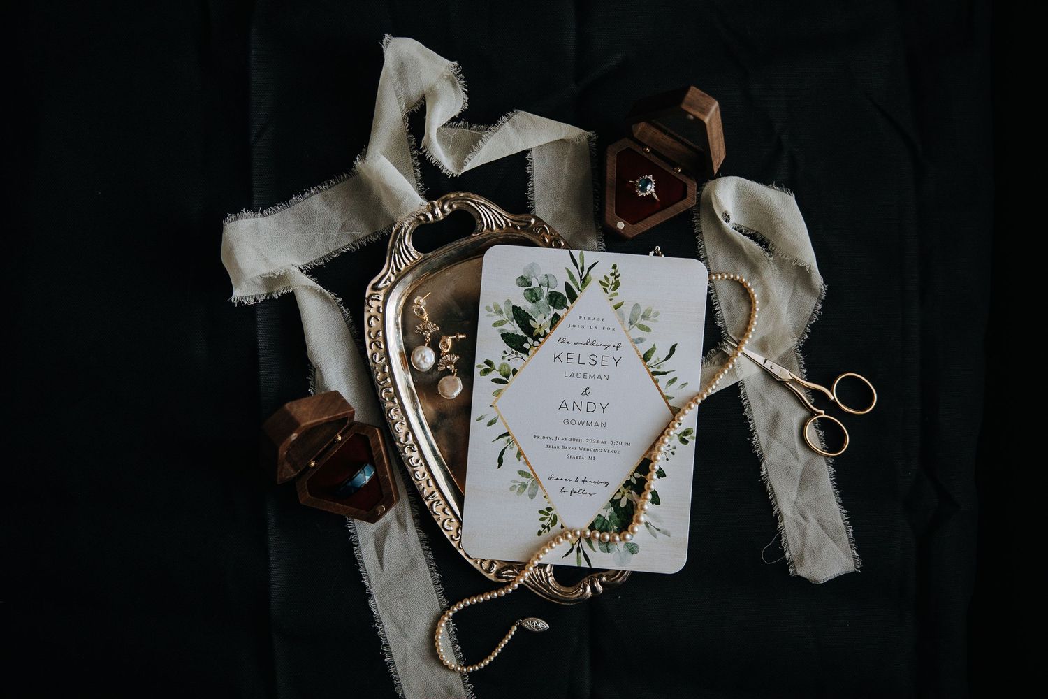 Elegant floral wedding invitation with gold details on white fabric.