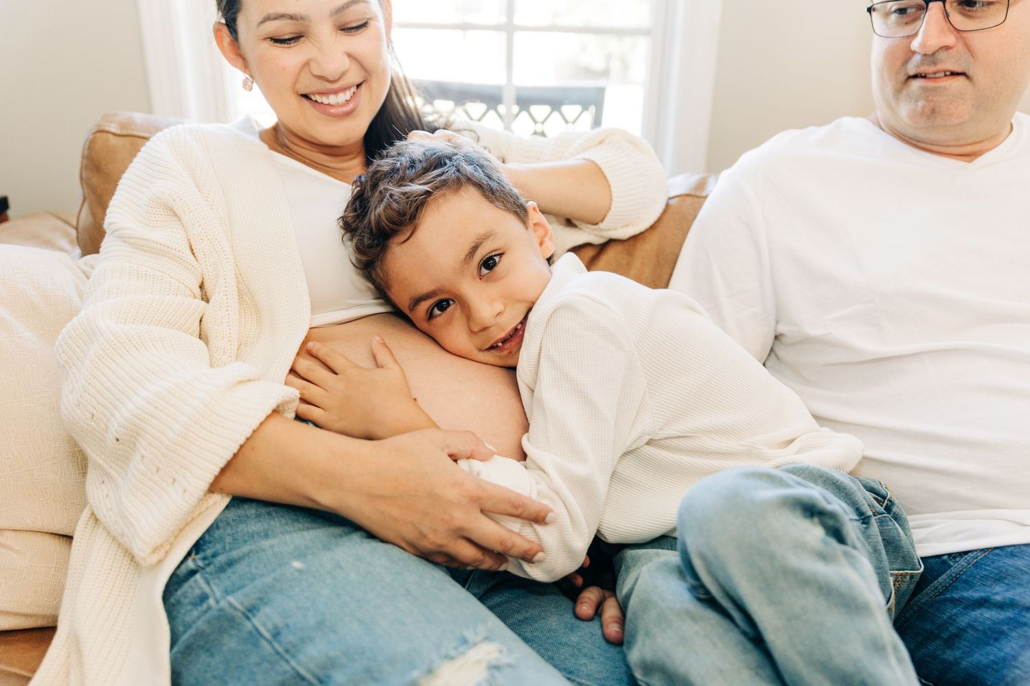 a young boy hugs his pregnant mother's belly