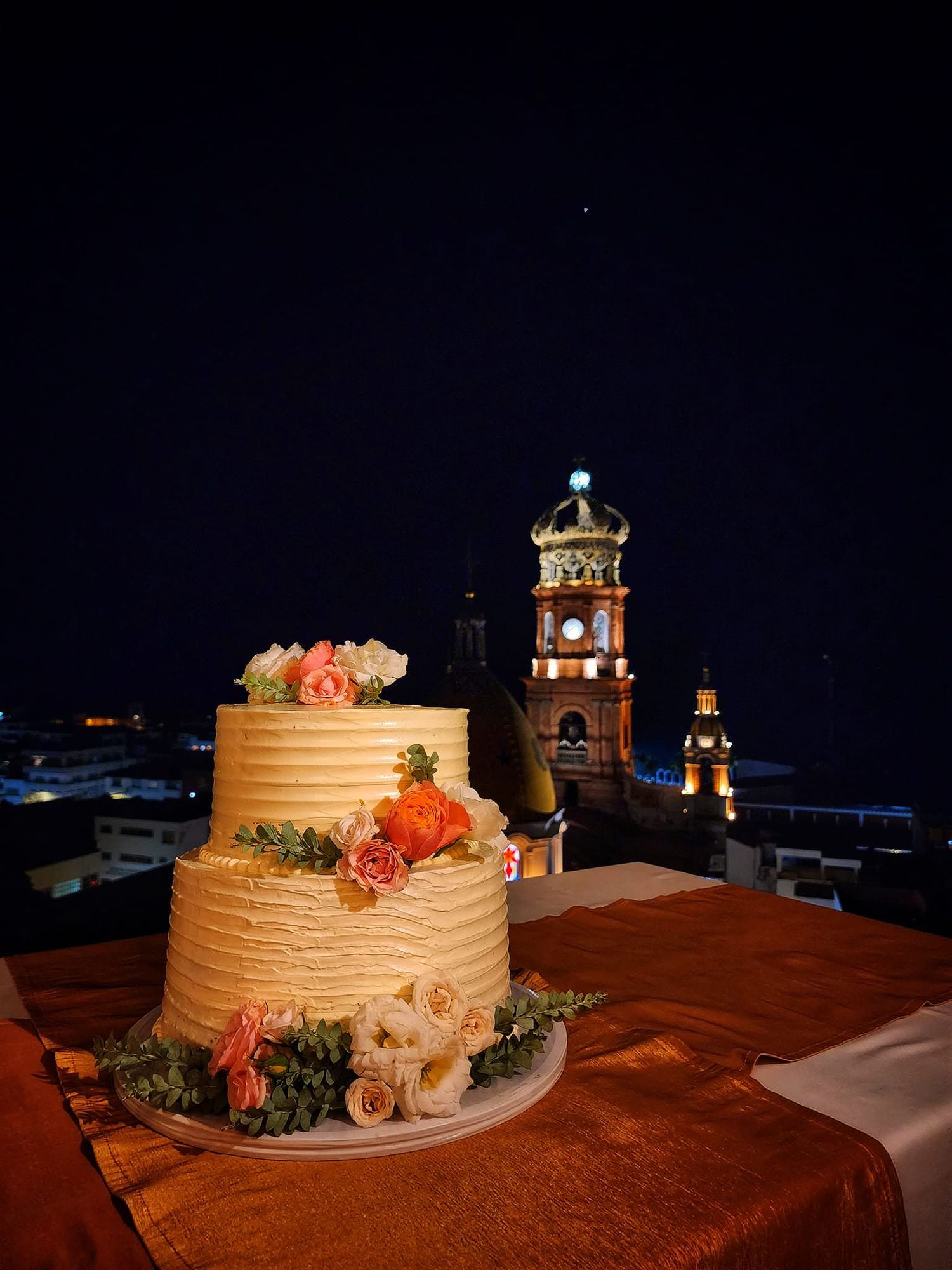 destination wedding cake at night in Puerto Vallarta Mexico with cathedral lights, captured by wedding content creator for real moments now!