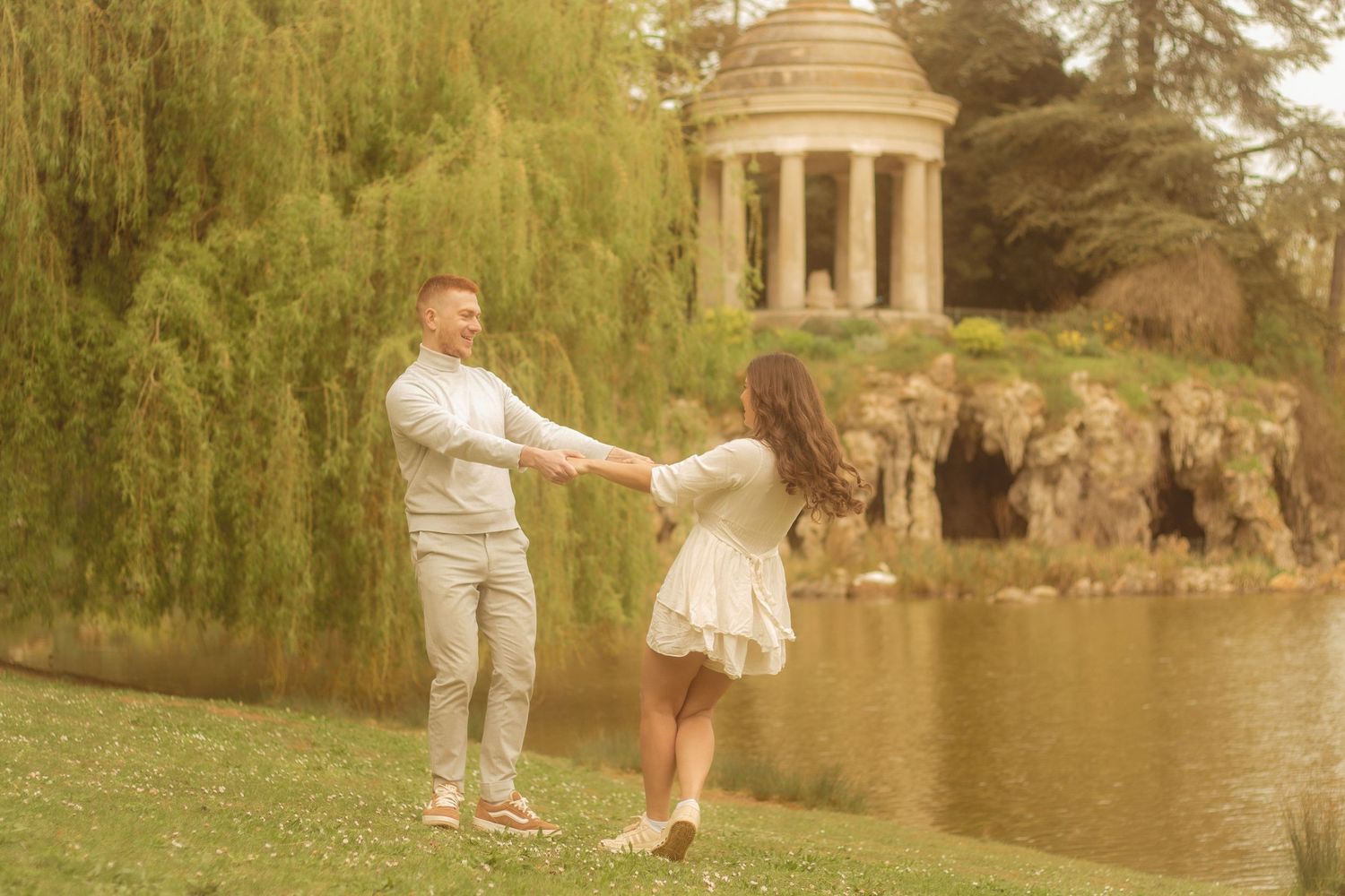 A couple is playing in the background there is a willow tree and a temple located in Bois de Vincennes.