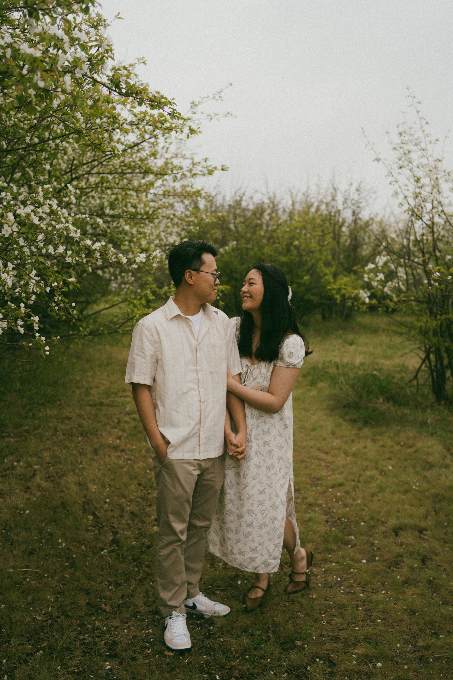 a couple look at each other in the blossoms