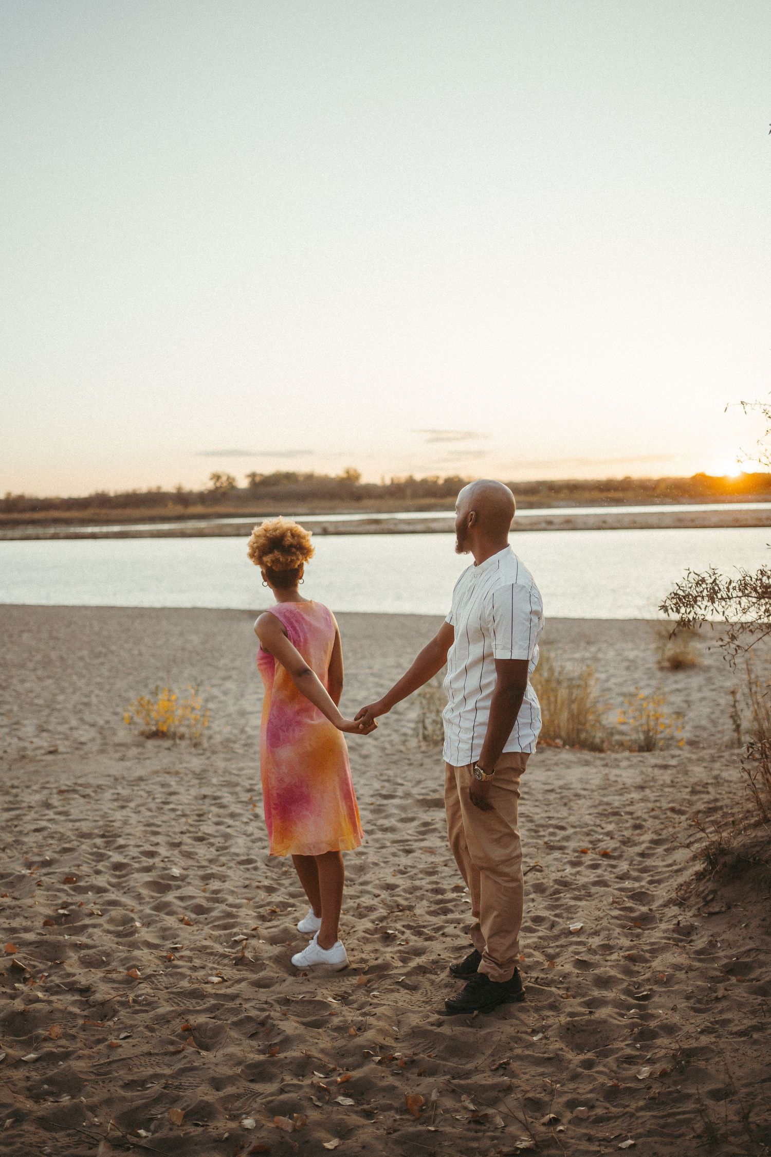 a couple hold hands at the beach