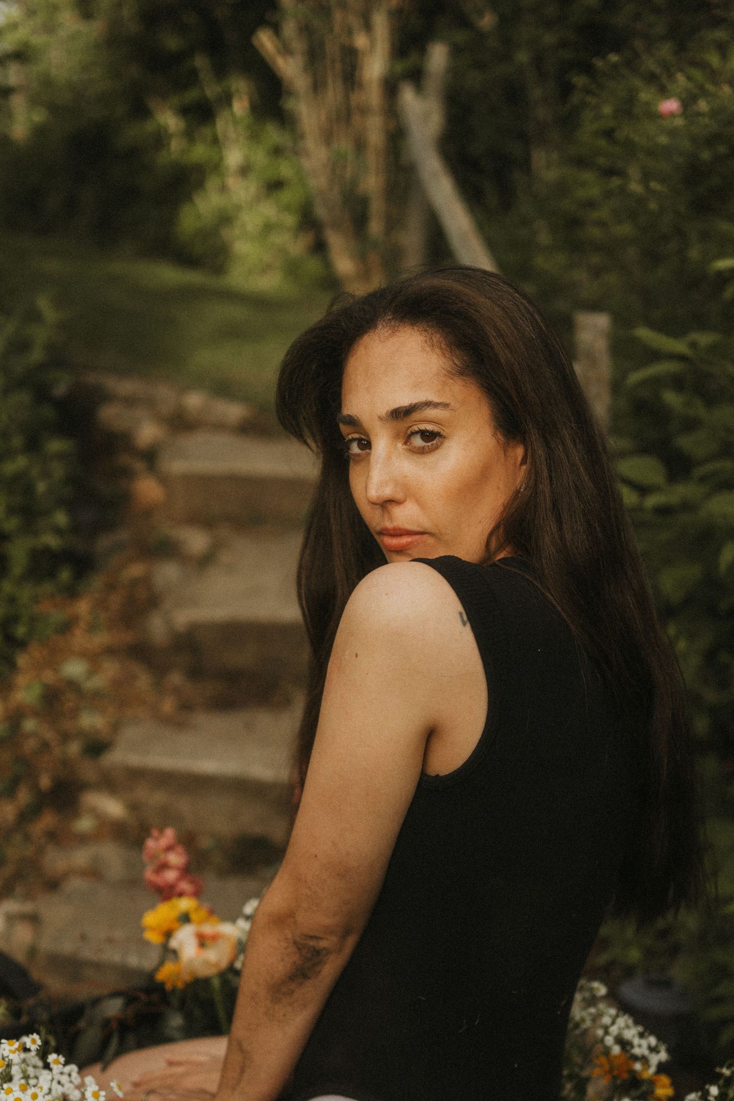 A creative photo of a woman sitting with flowers