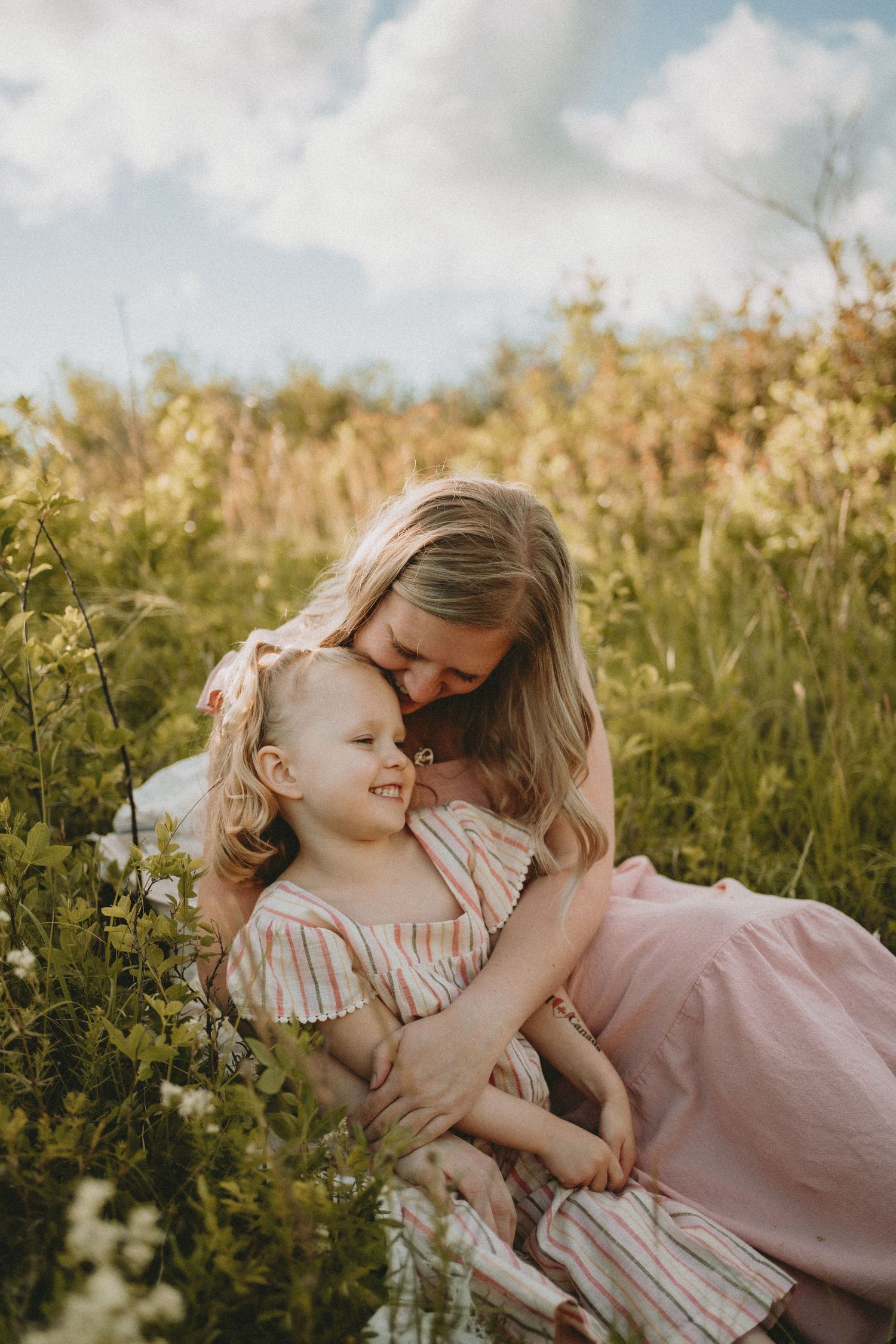 a mother holds her daughter in the flowers