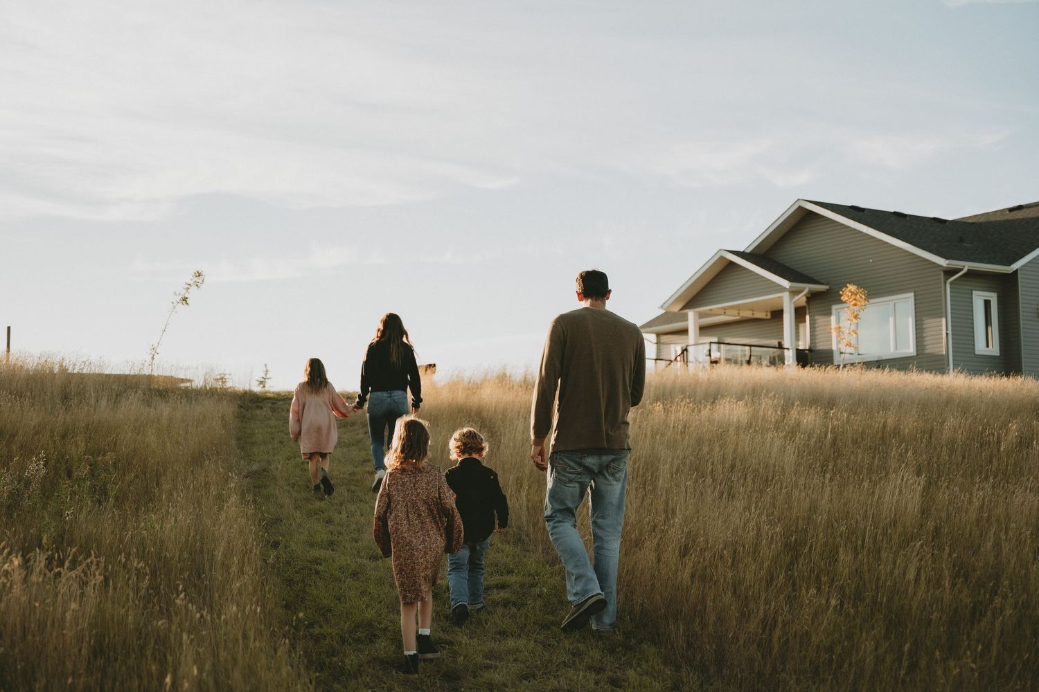a family walks in the field at their acreage