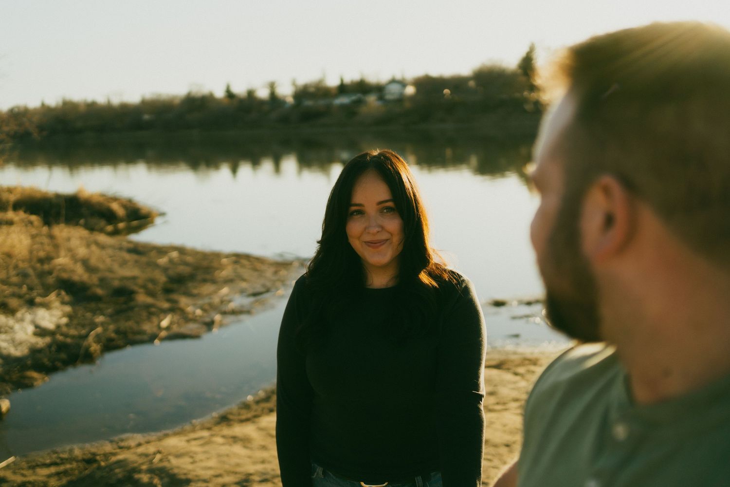 a man looks at his fiancee at the beach