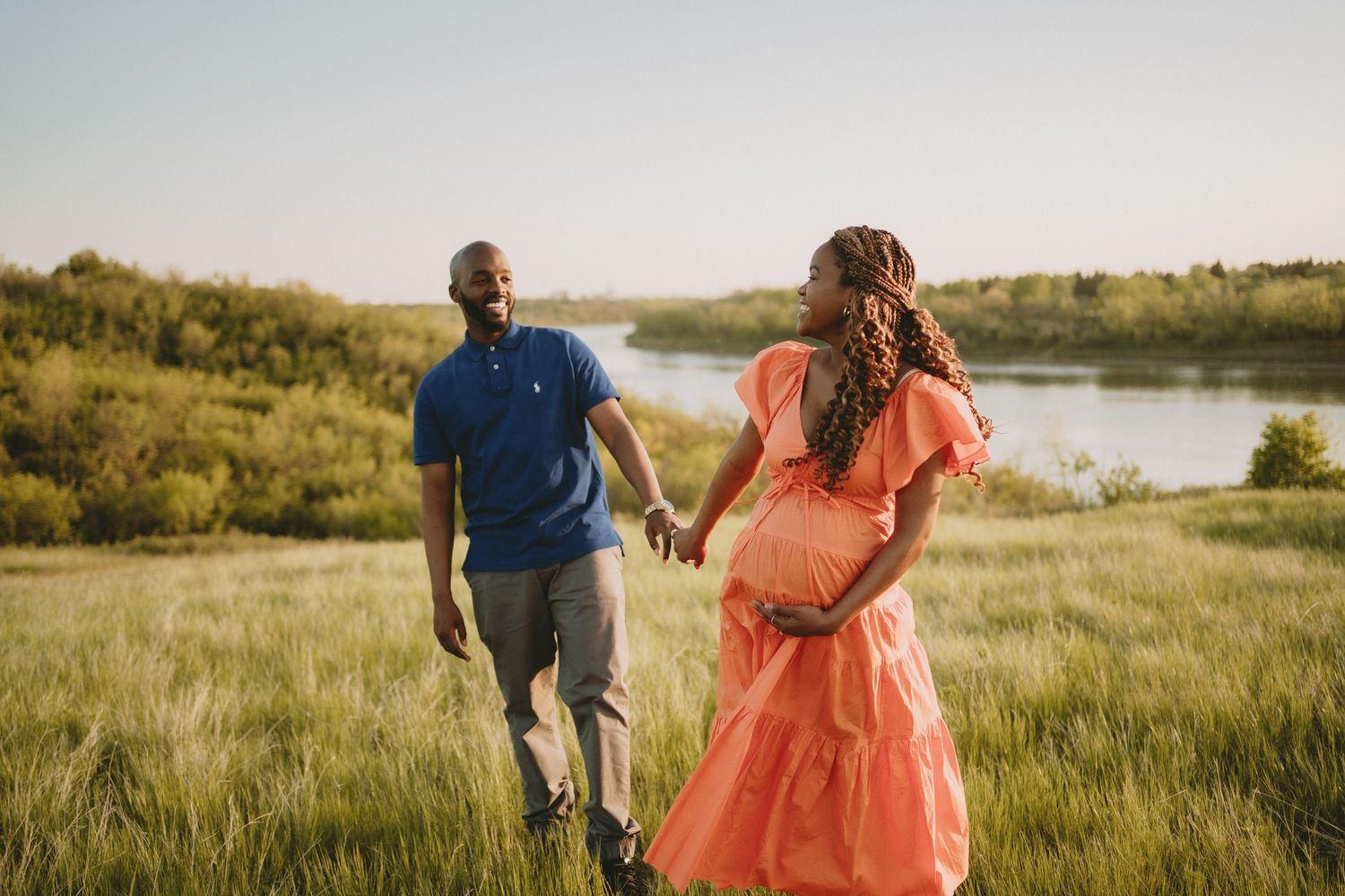 a maternity photo of a husband and wife at the river