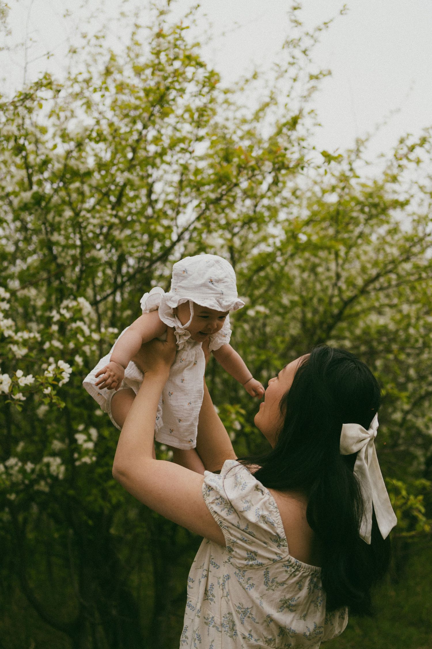 a mother holds her baby in the air