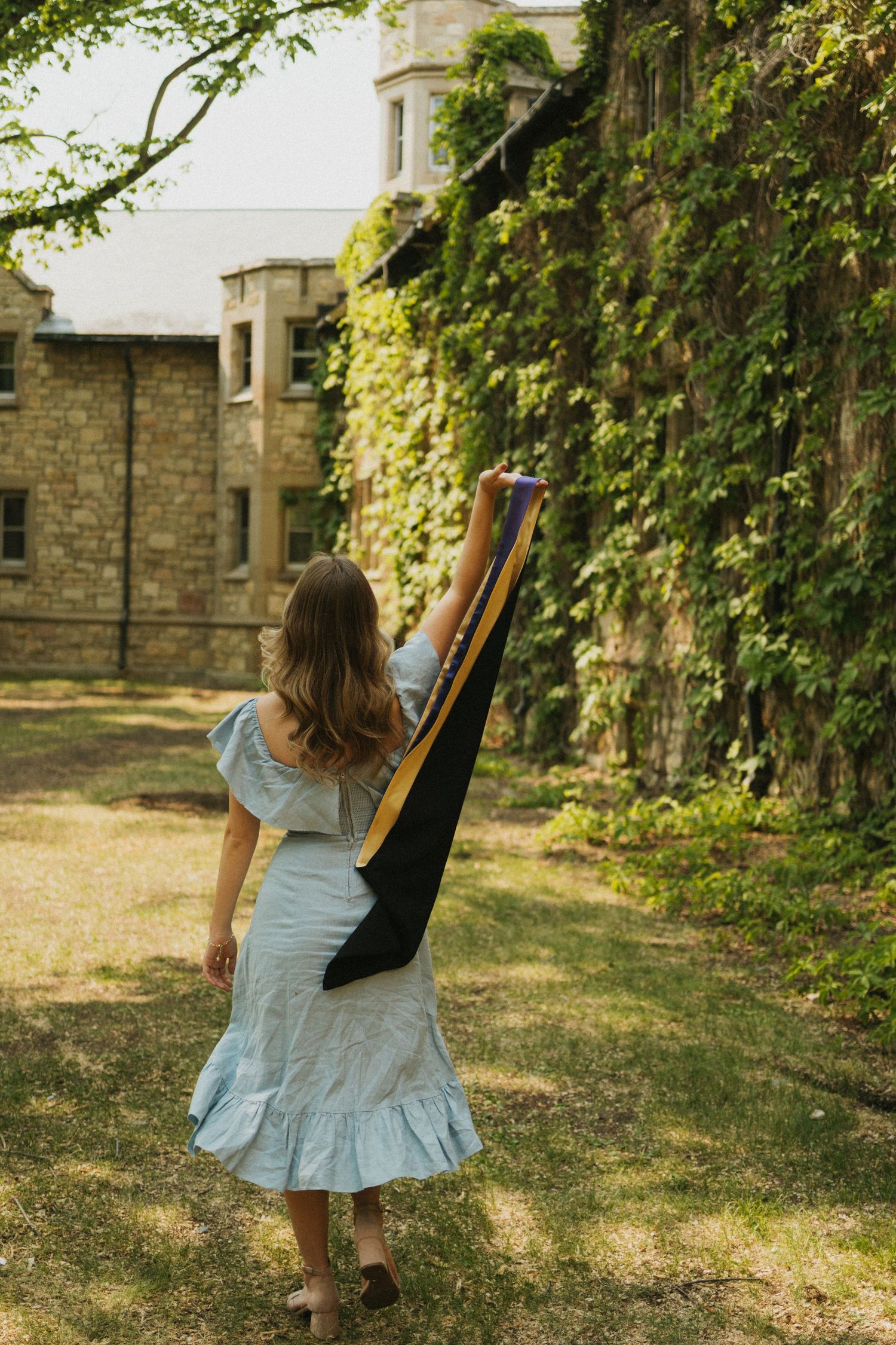 A graduate throws her sash over her shoulder