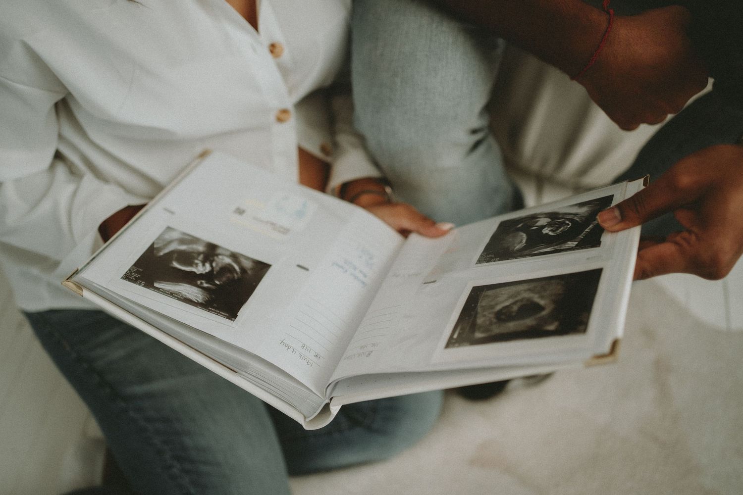 a couple looks at ultrasound photo. Maternity photos
