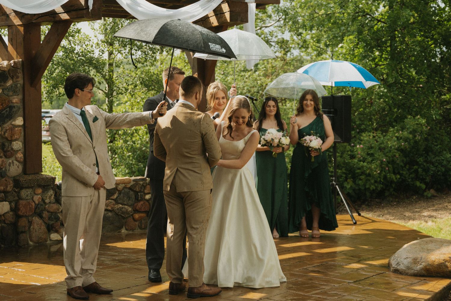 A couple at their wedding ceremony. The rain is falling down and they are sharing laughs. Candid.