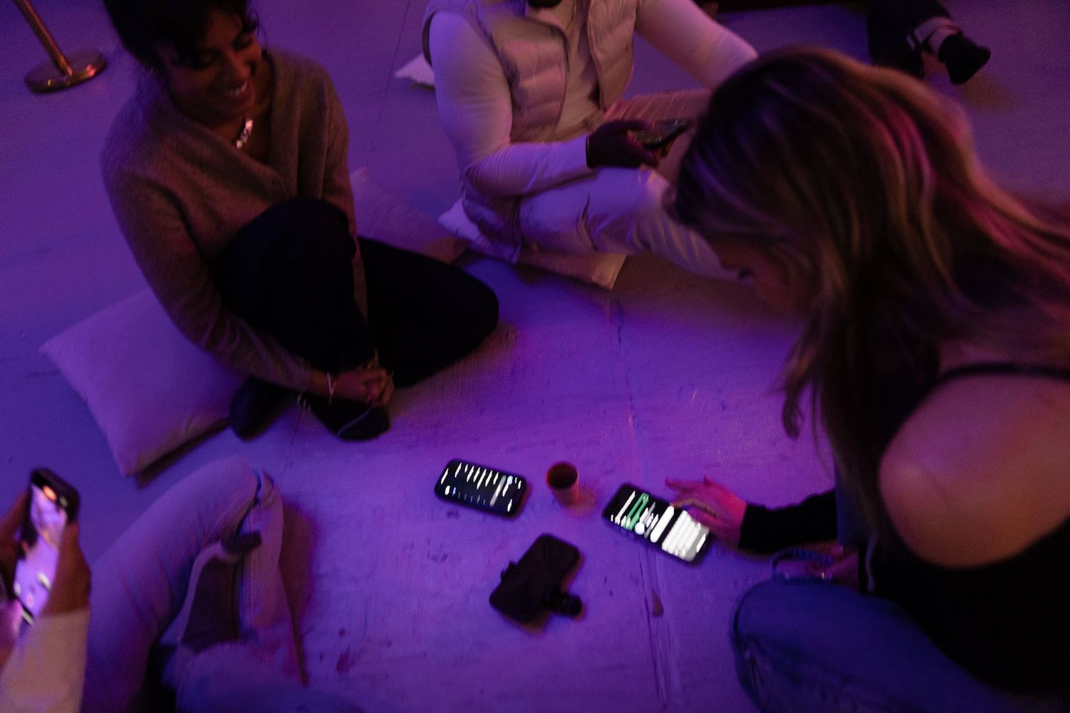 Group dancing in a darkly lit room with purple lighting casting atmospheric shadows.