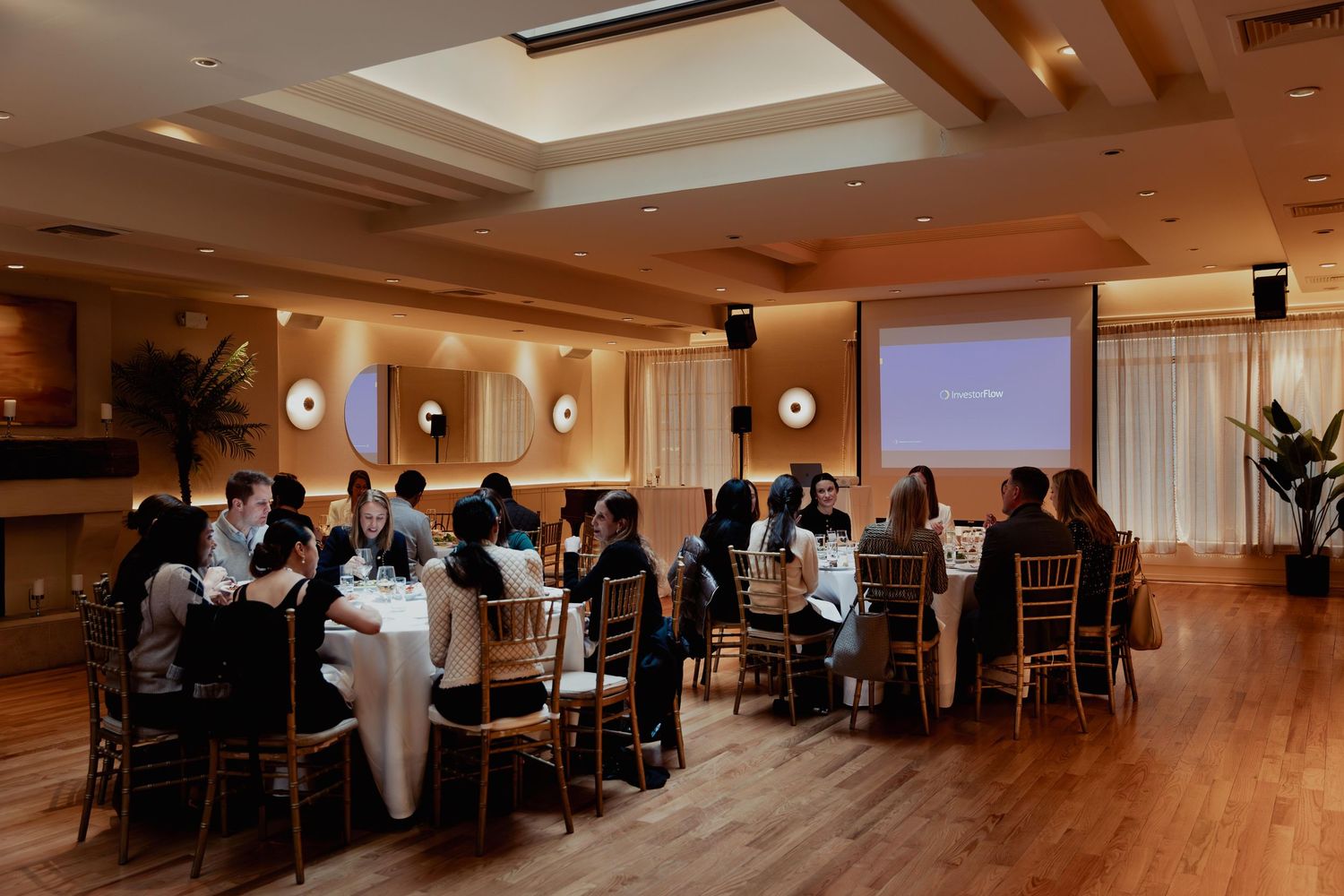 Panoramic view of an elegant banquet hall with tables and chairs set up for a formal event under recessed lighting.