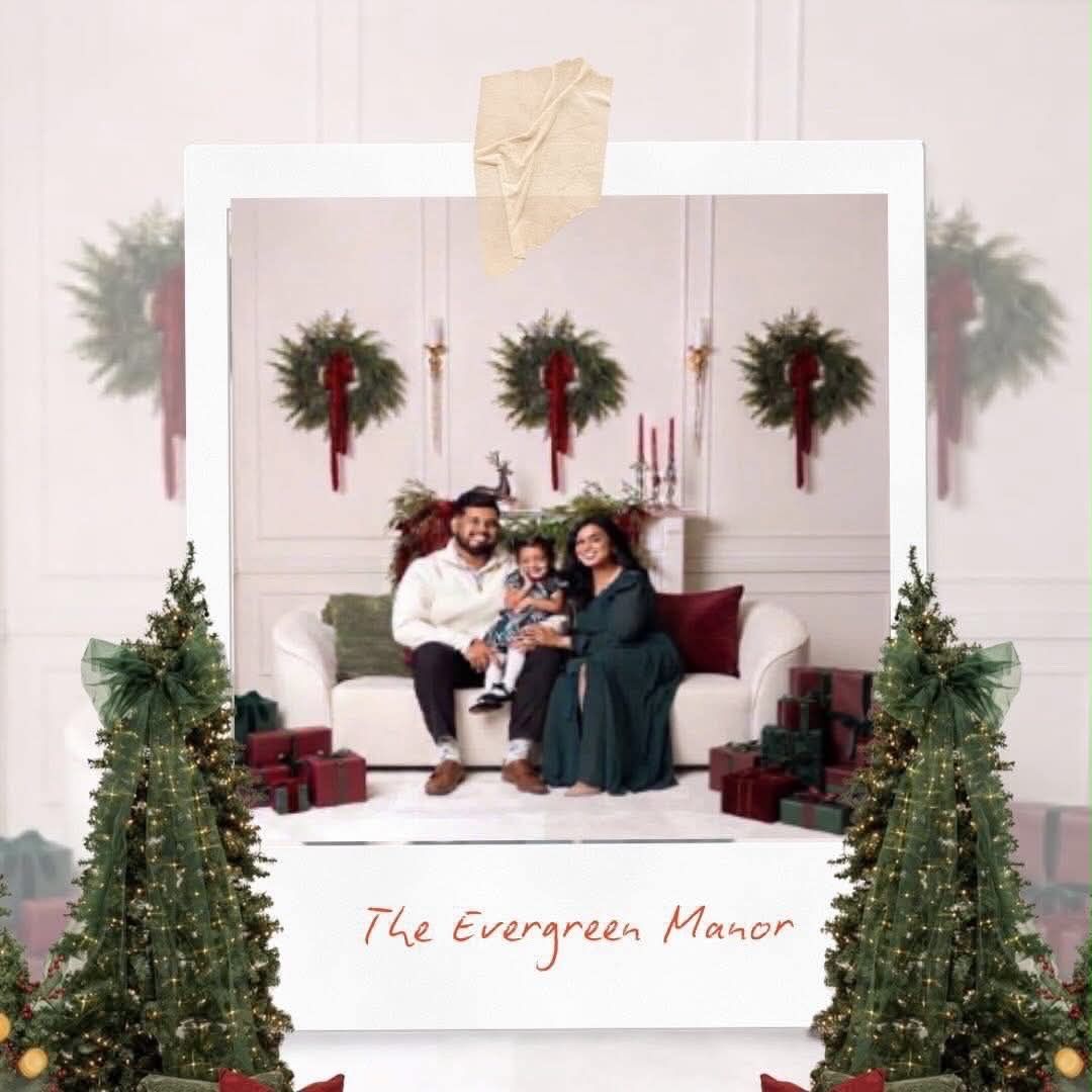 Family posing for a Christmas portrait at The Evergreen Manor with festive wreaths and holiday decor.