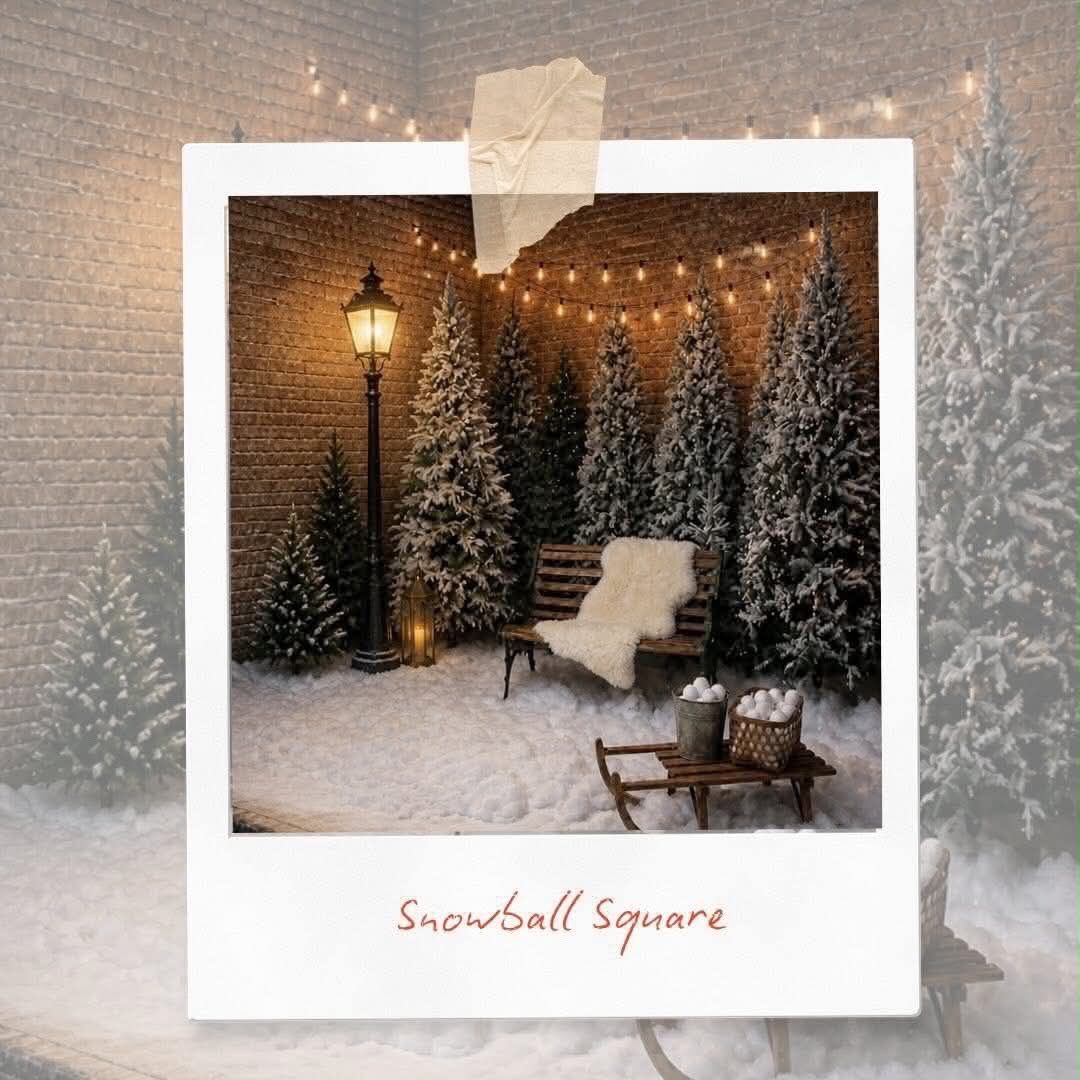 A festive Snowball Square Christmas scene with snow-flocked trees, string lights, a lantern, white chair, and sleigh on snowy ground.
