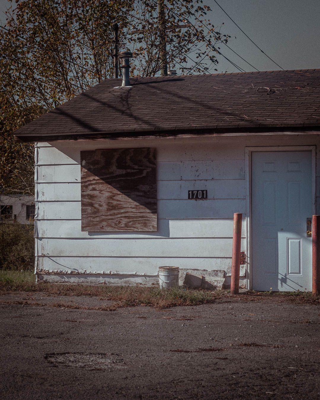A sequence of abandoned motel units with brown roofs and white walls shown from different angles in a desolate setting.