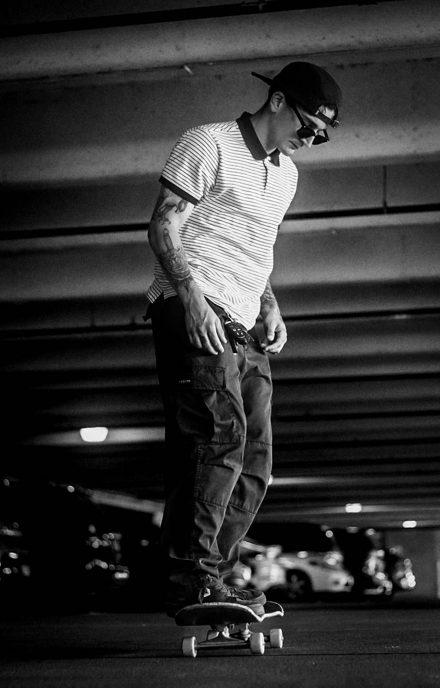 Black and white sequence showing a skateboarding trick in progress on a smooth indoor surface.