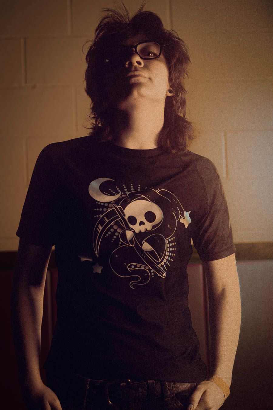 A series of photos showing someone wearing a black t-shirt with various skull and moon graphic designs.