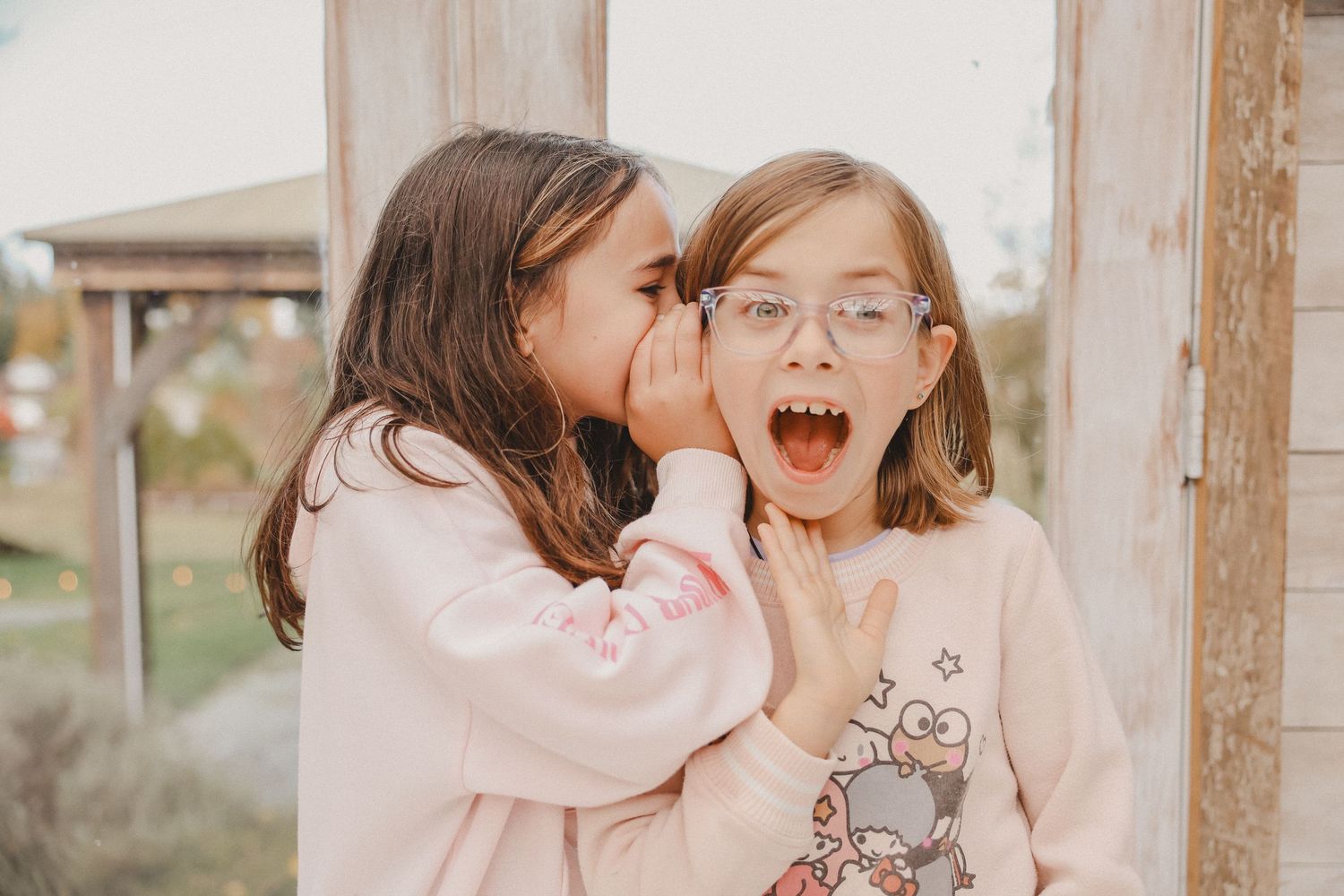 A collection of candid family photos showing joyful moments and laughter in soft pink tones and natural lighting.