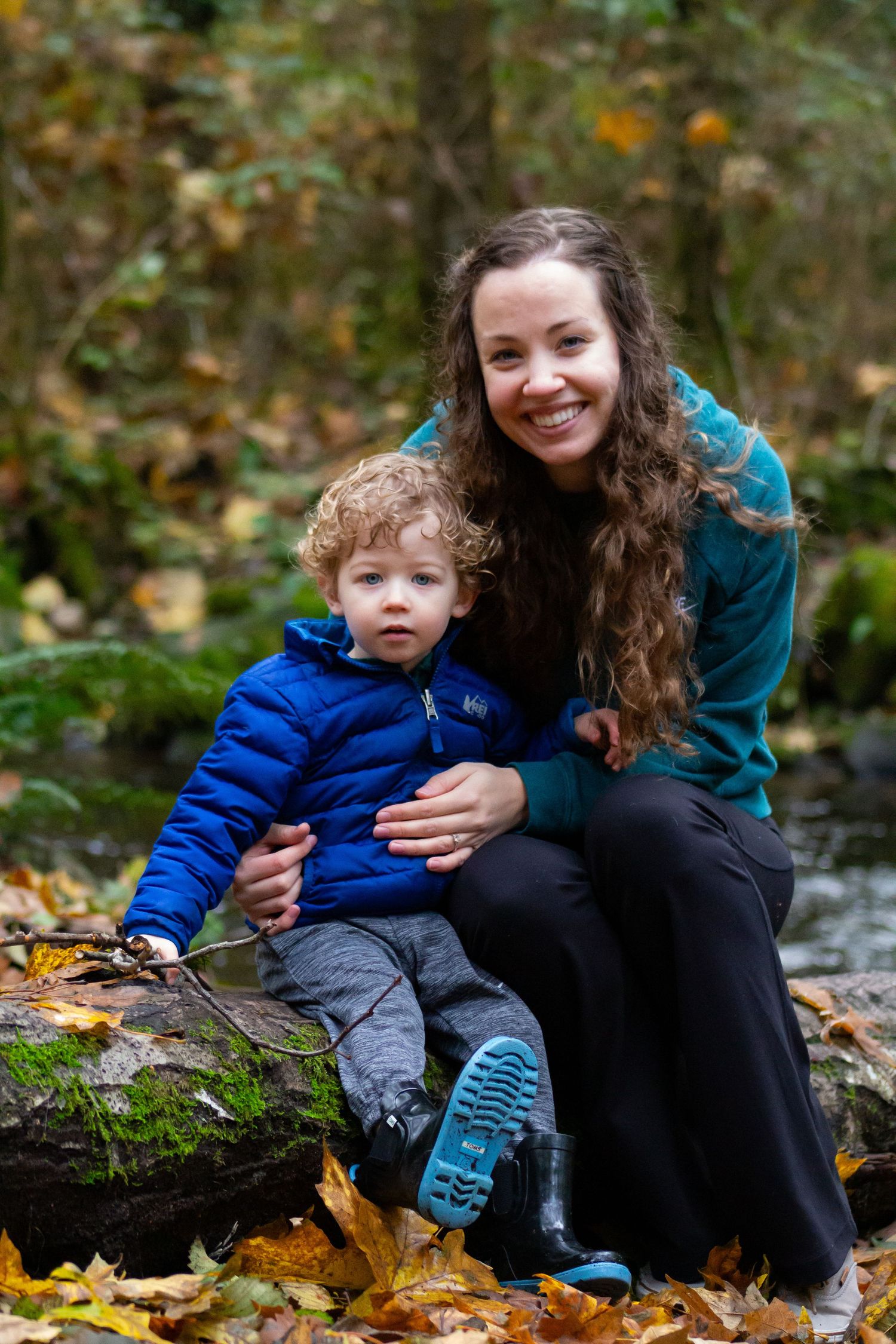 Autumn scene showing outdoor portrait on fallen leaves by a stream.