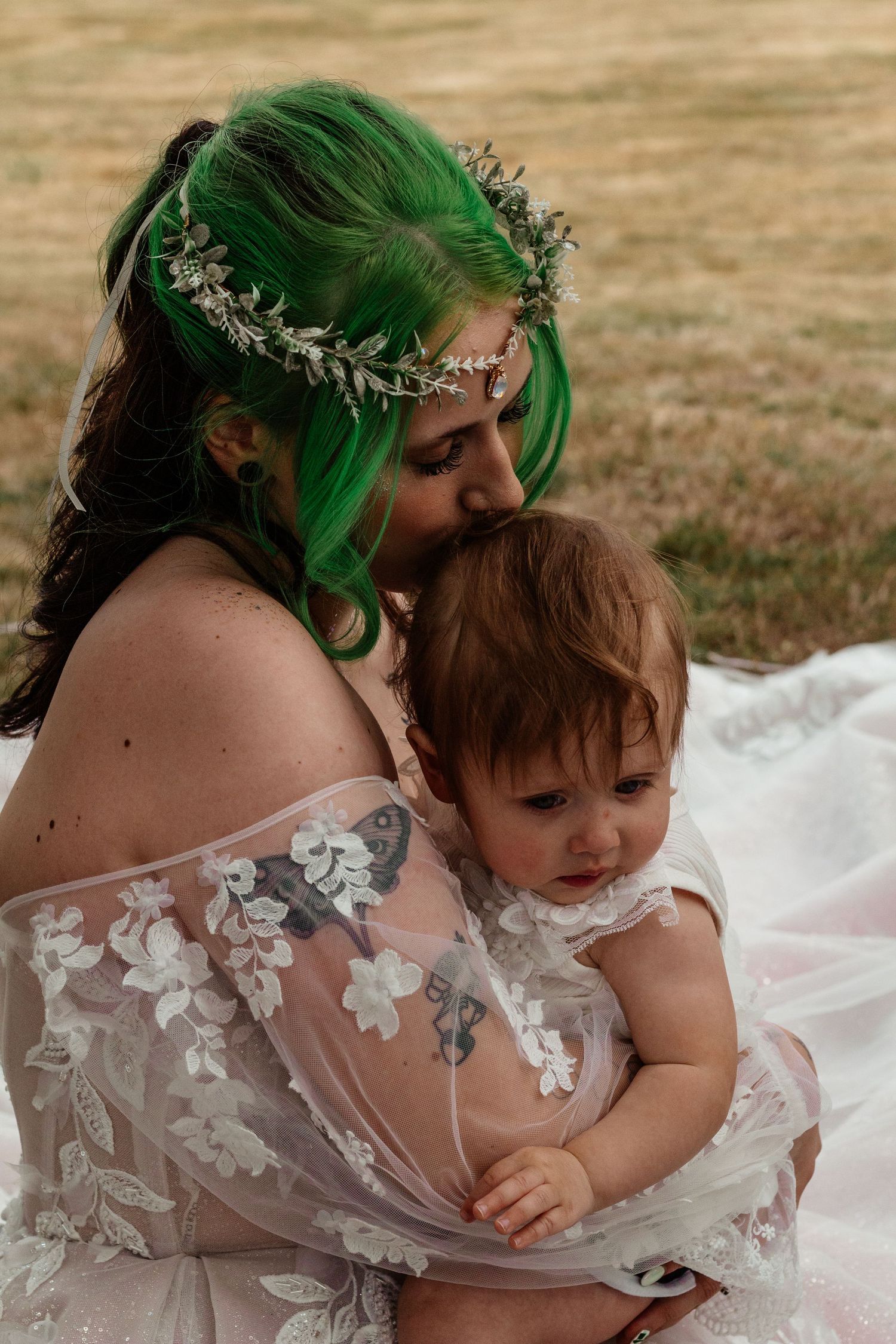 A series of four intimate photos showing a tender moment between a parent in a white lace dress and small child.