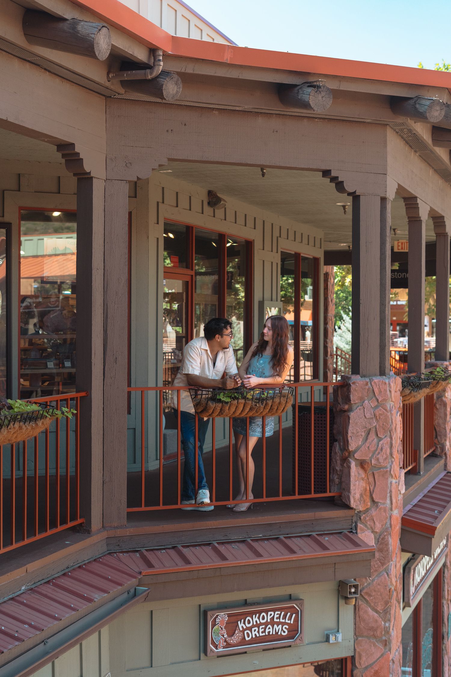 Couple enjoying views from a balcony at Kokopelli Dreams shop in a Southwestern-style building.