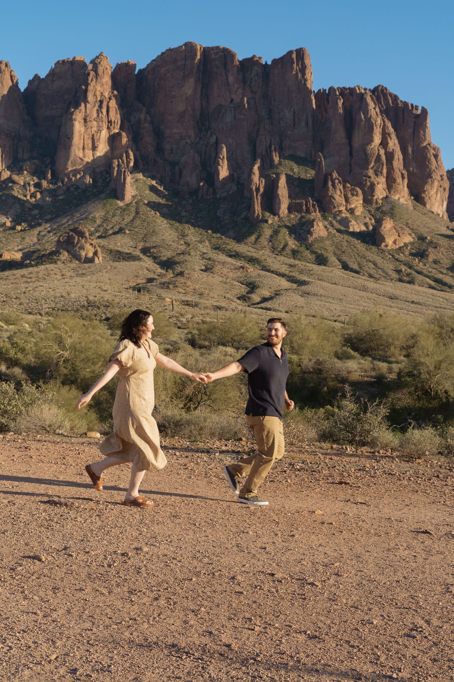 A sequence of desert landscape photos shows two people jumping and posing playfully against dramatic mountain cliffs.