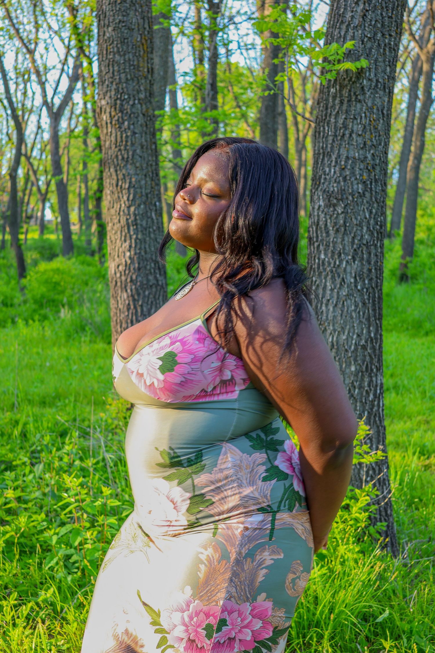 Spring portrait session in a wooded area with lush green foliage.