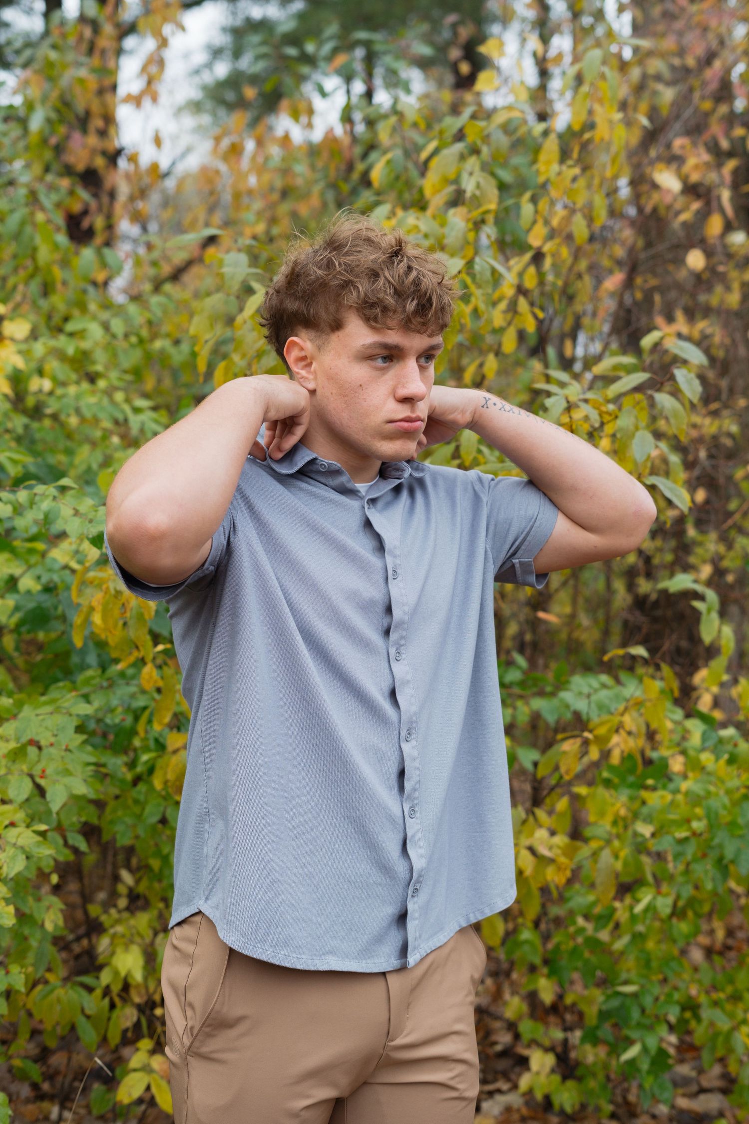 A person in a gray polo shirt and khaki pants poses against autumn foliage in a sequence of similar shots.