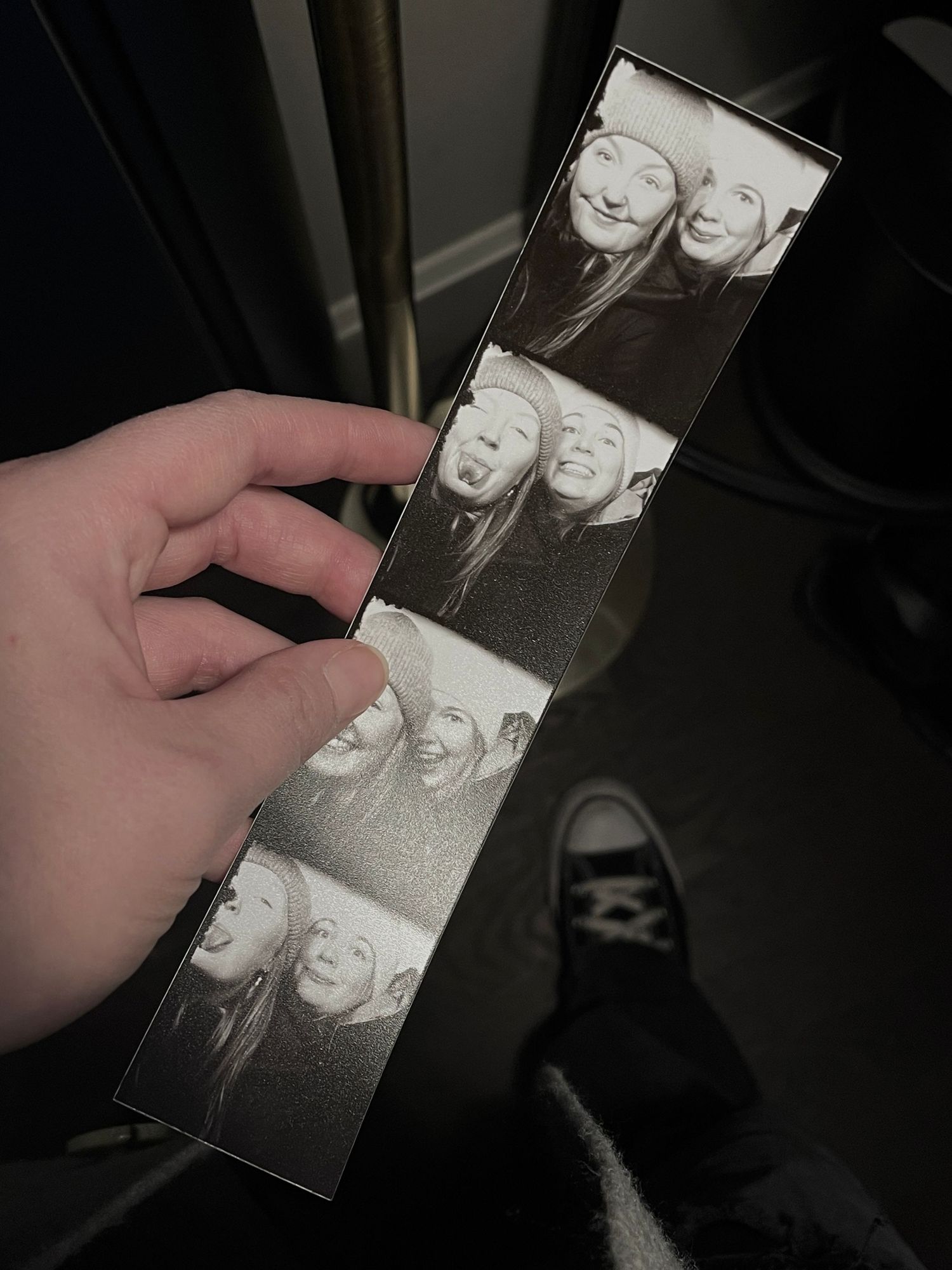 Black and white photo booth strip showing two friends making fun poses and expressions across four frames.