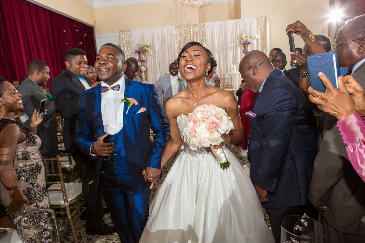 Joyful bride and groom walking triumphantly at their wedding reception celebration.