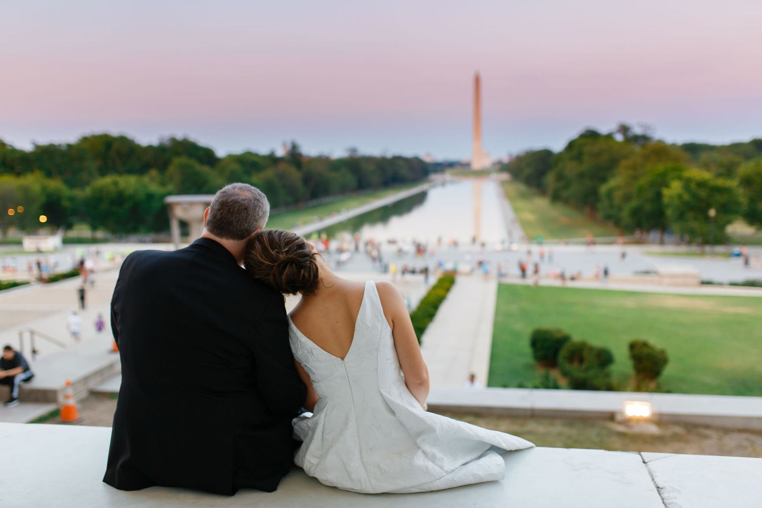 Newlywed couple sitting together overlooking the National Mall and Washington Monument at sunset in DC.