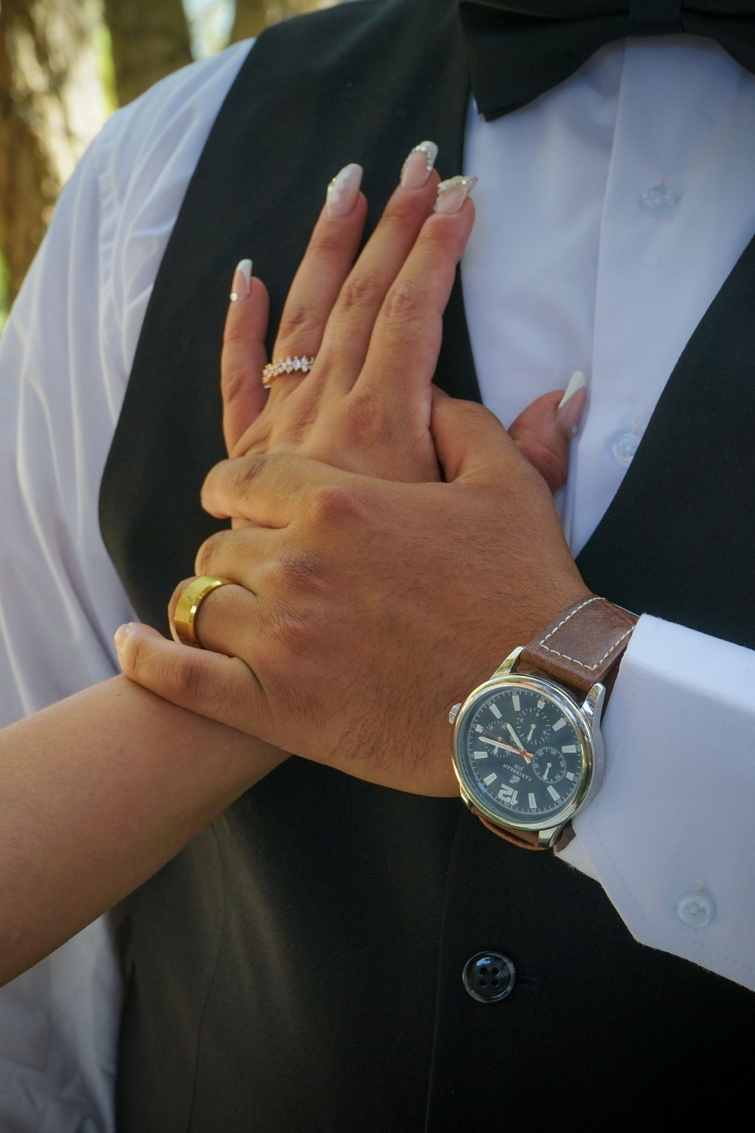 Bride resting her hand on the groom’s chest as they hold hands and smile at each other after their outdoor wedding.